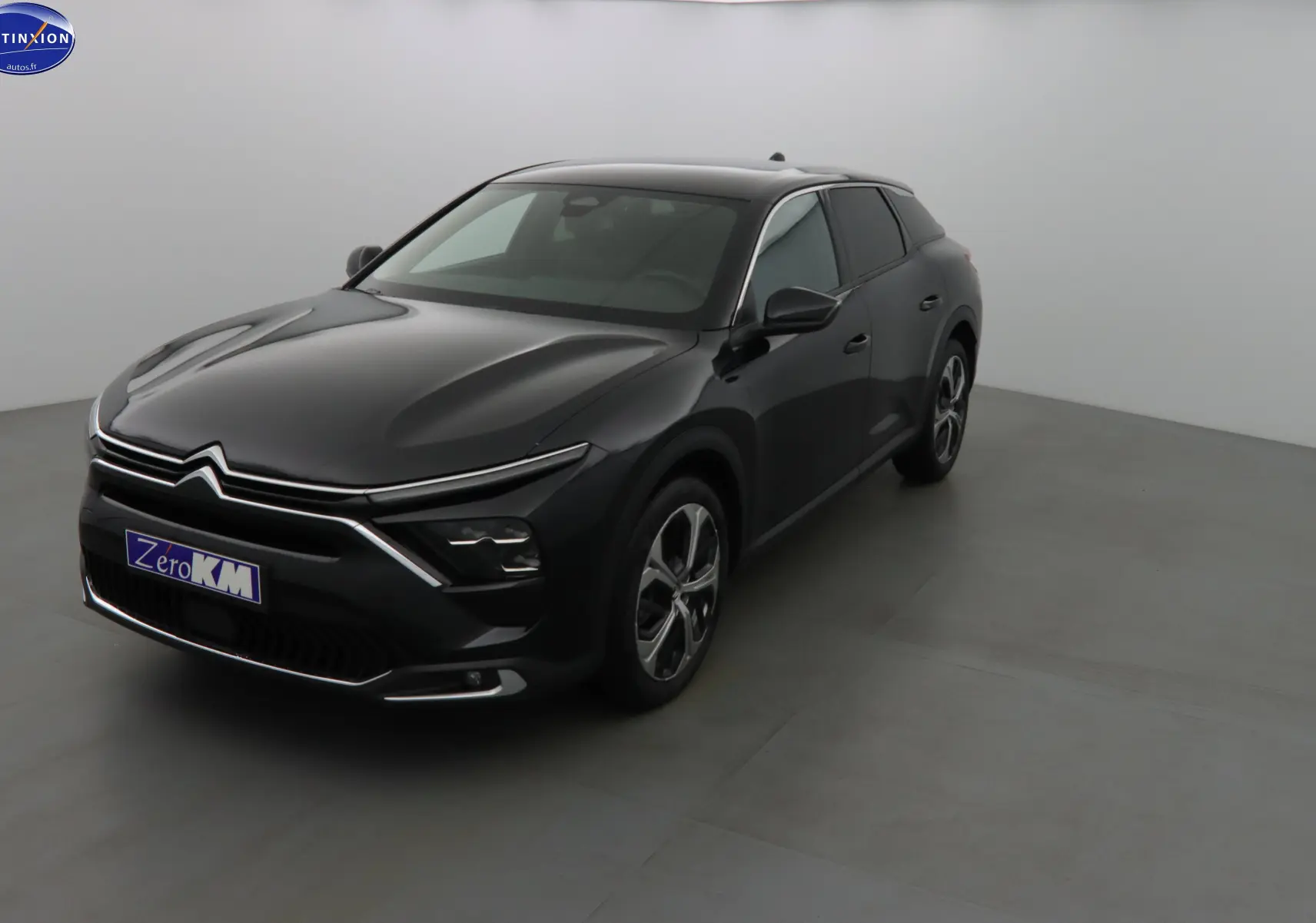 Citroën C5 X noir métal vue 3/4 avant droit dans un studio, avec ses lignes modernes et phares LED distinctifs.