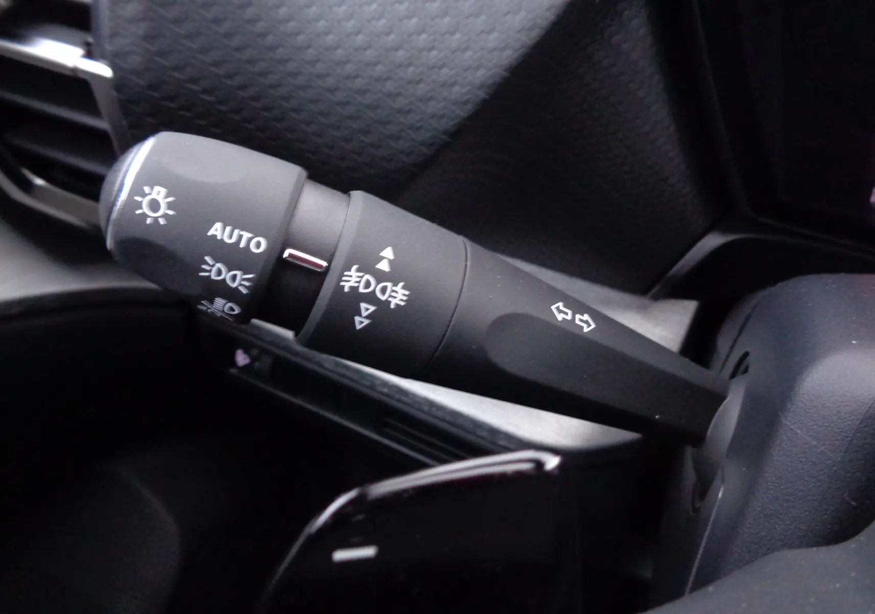 Gros plan sur la manette de clignotants et feux du tableau de bord noir du Citroën C5 X 2023 finition Feel Pack.