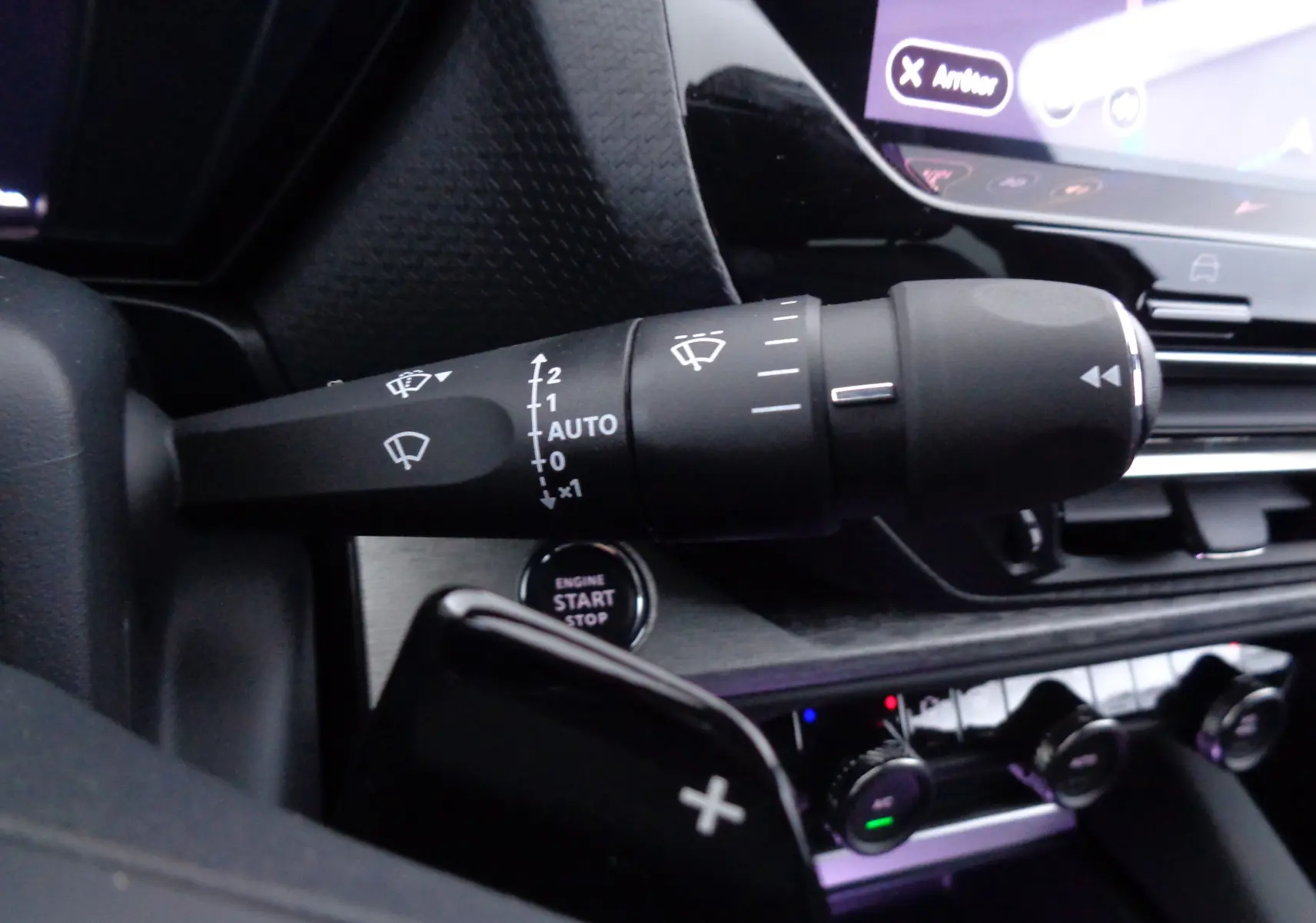 Gros plan sur la commande d'essuie-glace à gauche du volant dans l'habitacle noir du Citroën C5 X 2023.