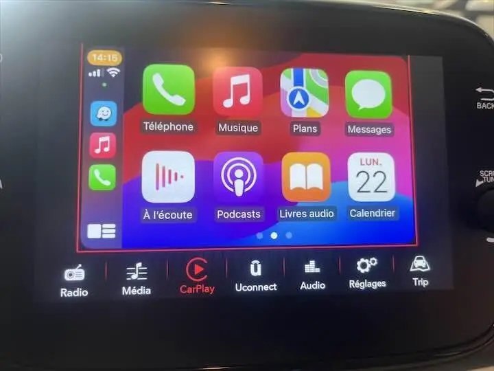 Écran tactile multimédia de la Fiat 500 2023 affichant Apple CarPlay avec icônes colorées en intérieur du véhicule.