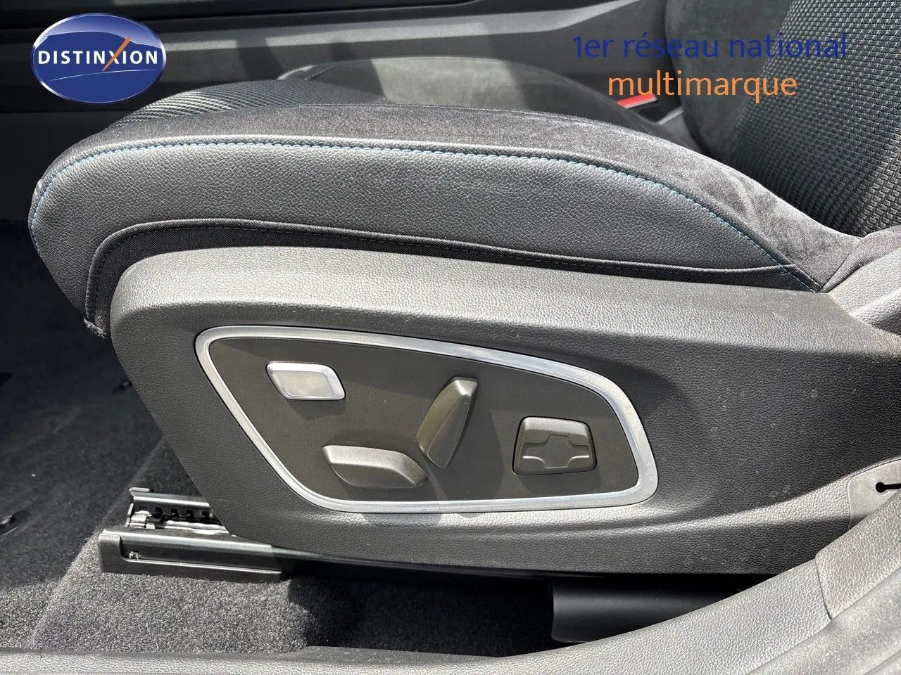 Gros plan sur les commandes électriques du siège conducteur en cuir noir avec surpiqûres bleues du Renault Austral hybride.