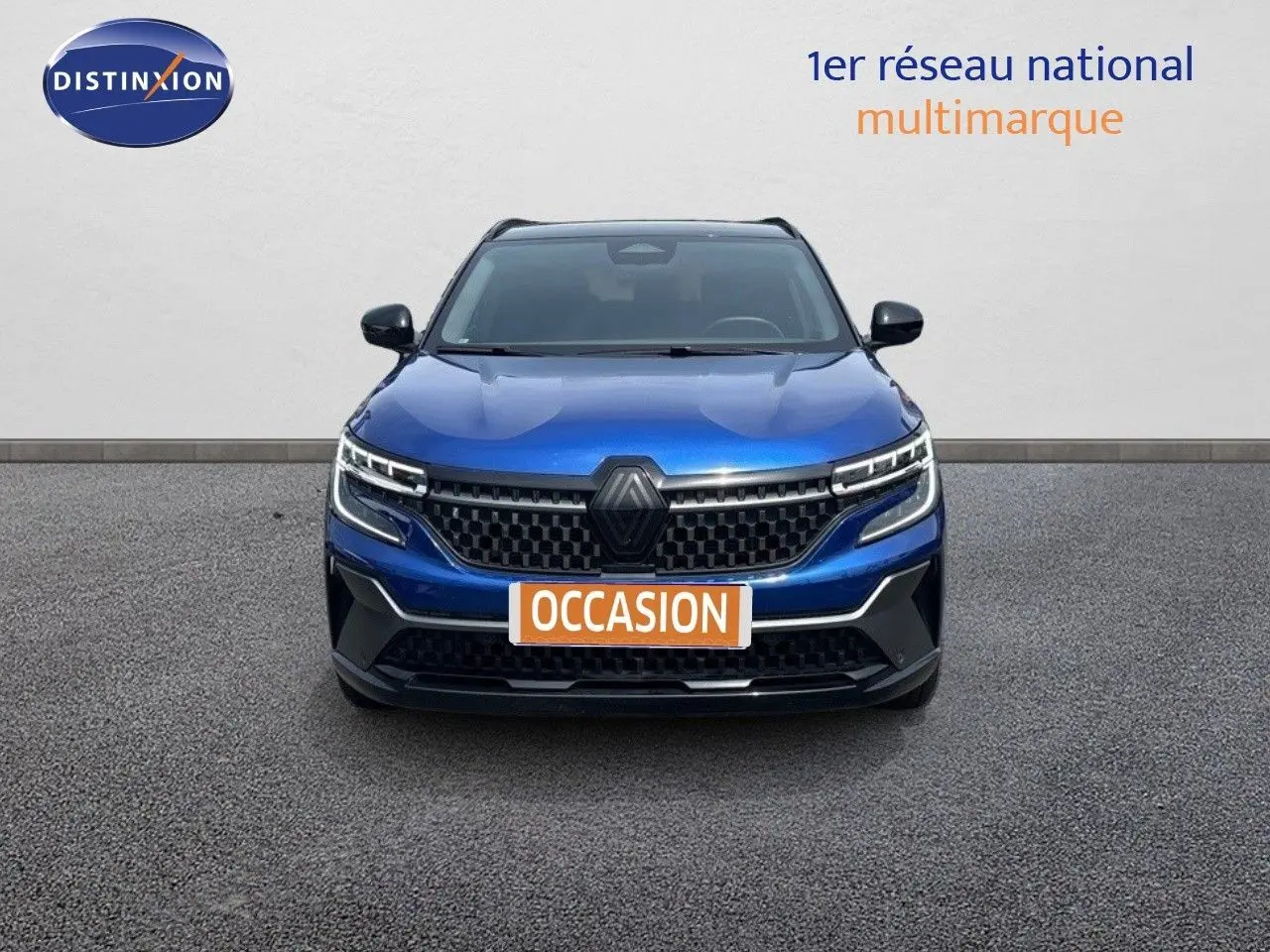 Vue frontale d'un Renault Austral E-Tech hybride bleu Iron Metal avec toit noir, calandre et phares LED distinctifs.