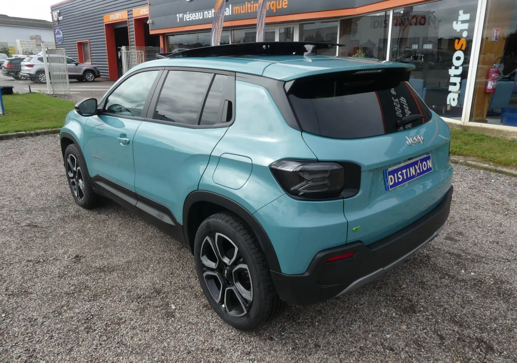 Vue 3/4 arrière droite d'un Jeep Avenger bleu métallisé avec vitres surteintées et jantes alliage 18 pouces.