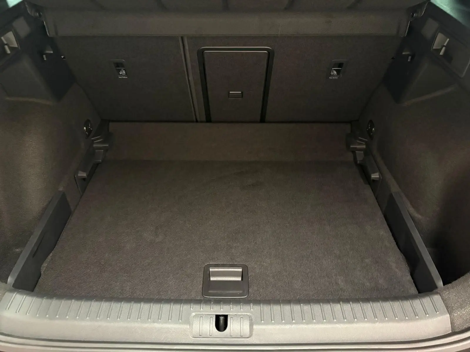 Coffre spacieux et vide du CUPRA Formentor gris magnétique, vue de l'arrière avec plancher plat et finitions noires.