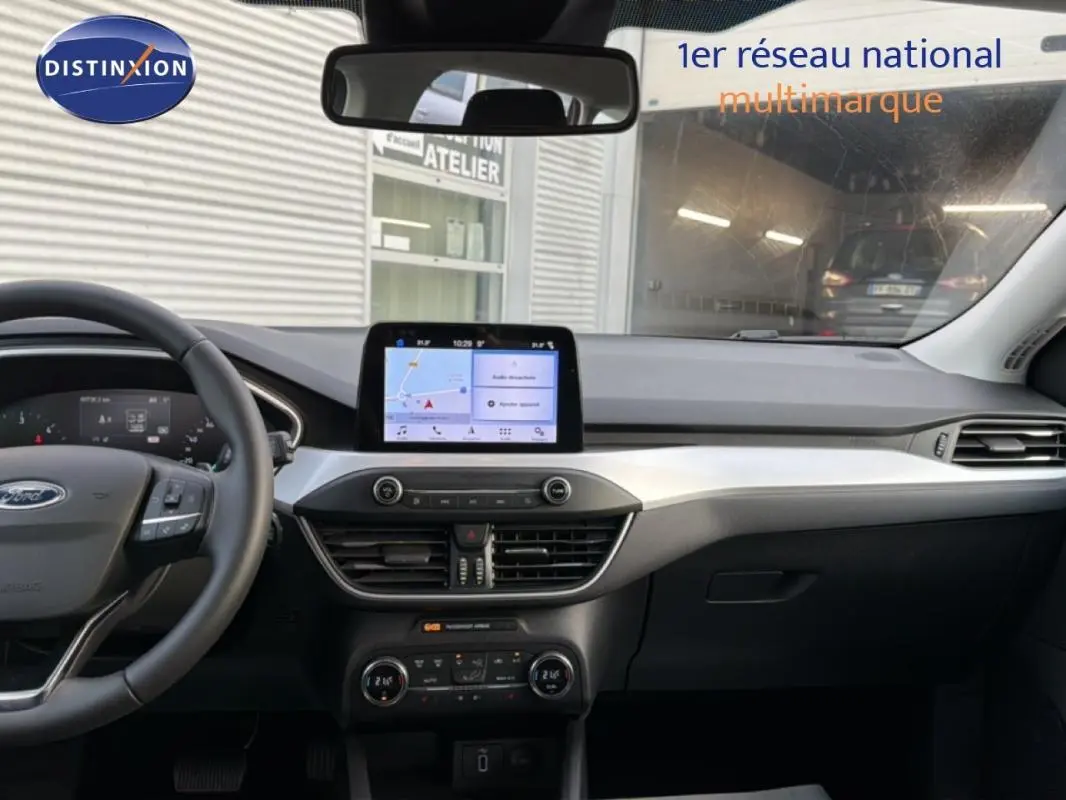 Vue intérieure avant de la Ford Focus SW 2019 noire, mettant en valeur le tableau de bord avec écran tactile et volant multifonction.