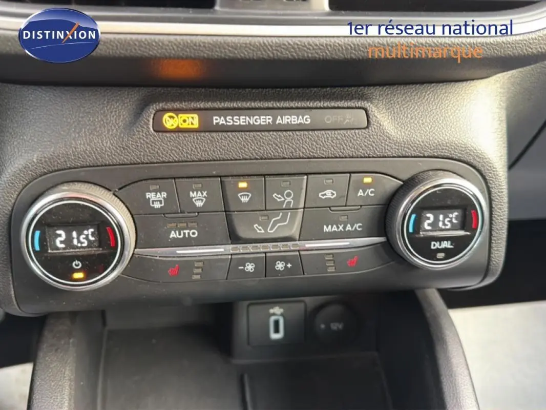 Gros plan sur la console de climatisation automatique de la Ford Focus SW noire, affichant 21,5°C en mode dual.