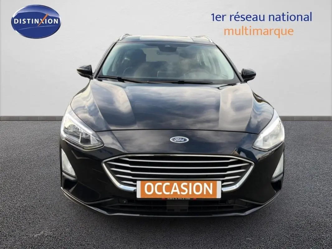 Vue frontale d'une Ford Focus SW noire 2019 avec calandre chromée et feux allumés sur fond neutre.