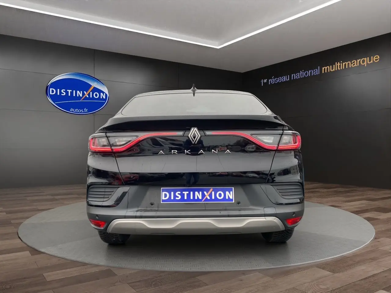 Vue arrière du Renault Arkana noir 2024 avec feux LED continus et logo distinctif sur fond showroom.