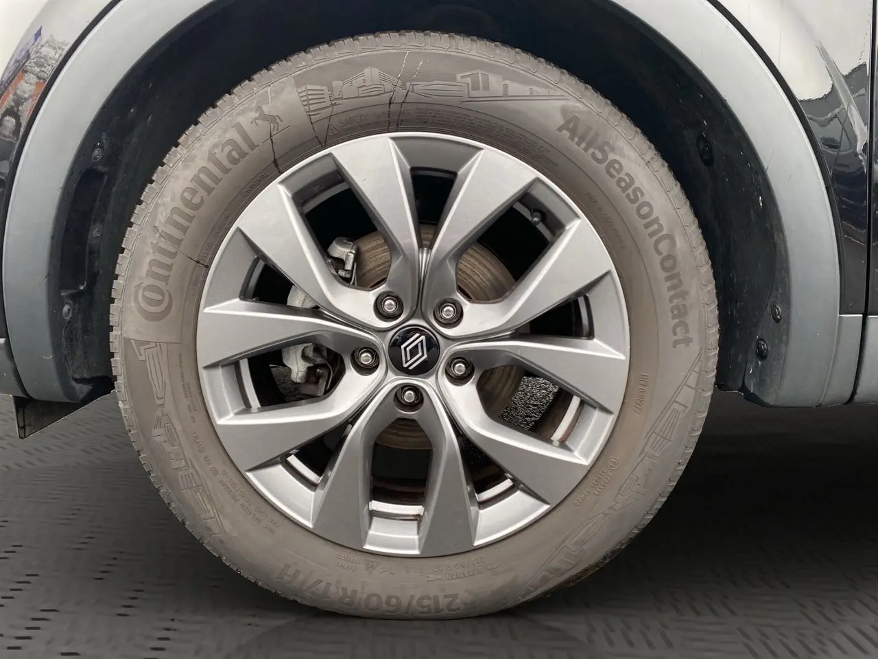 Gros plan sur la roue avant droite du Renault Arkana noir 2024 avec jante alliage et pneu Continental AllSeasonContact.