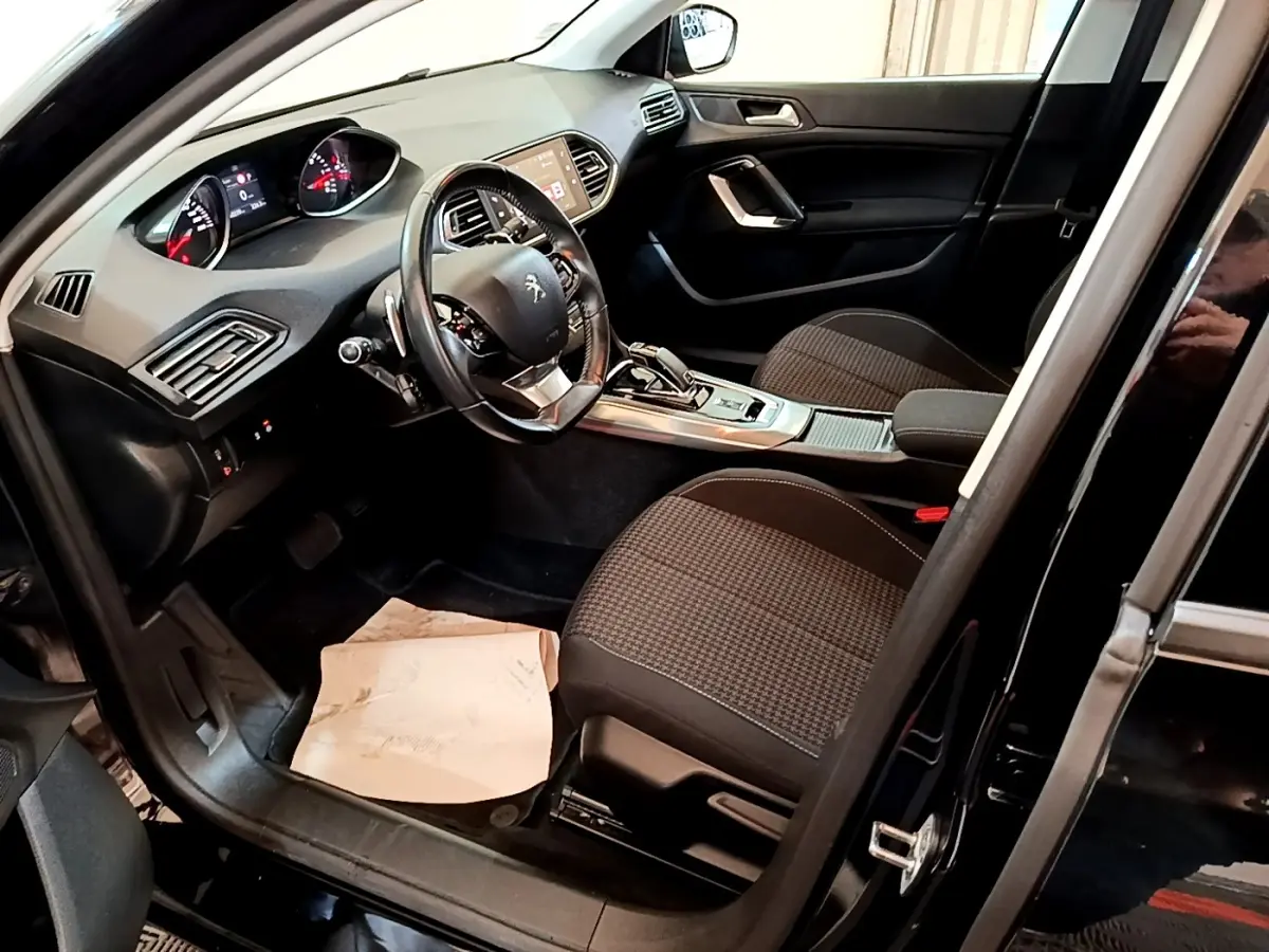 Intérieur noir de la Peugeot 308 2020, vue côté conducteur avec tableau de bord et volant multifonctions visibles.