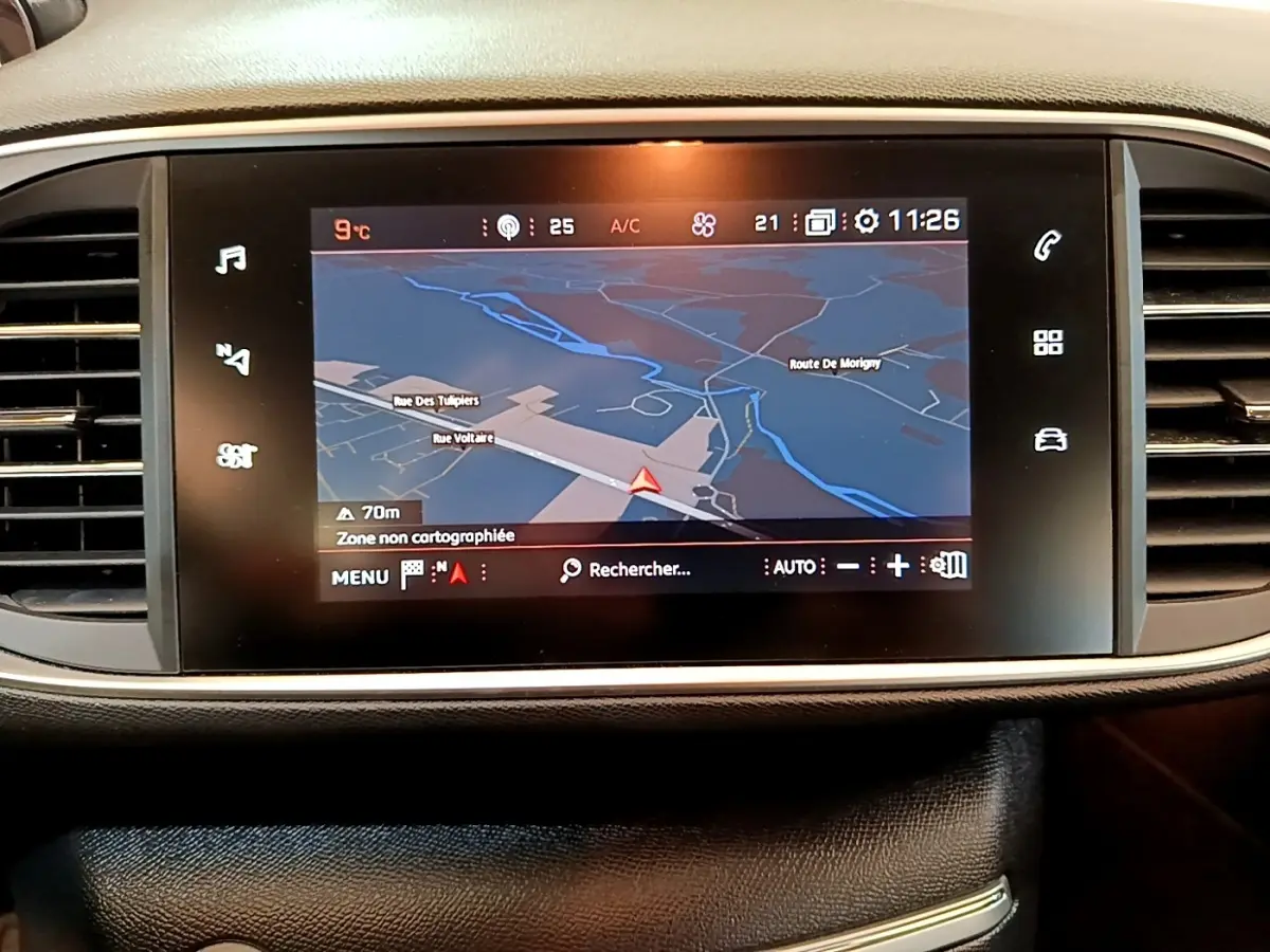 Écran tactile central du tableau de bord de la Peugeot 308 noir, affichant la navigation GPS en mode nuit.