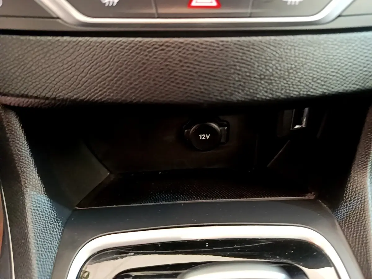 Gros plan sur la prise 12V et port USB dans la console centrale noire d'une Peugeot 308 2020.
