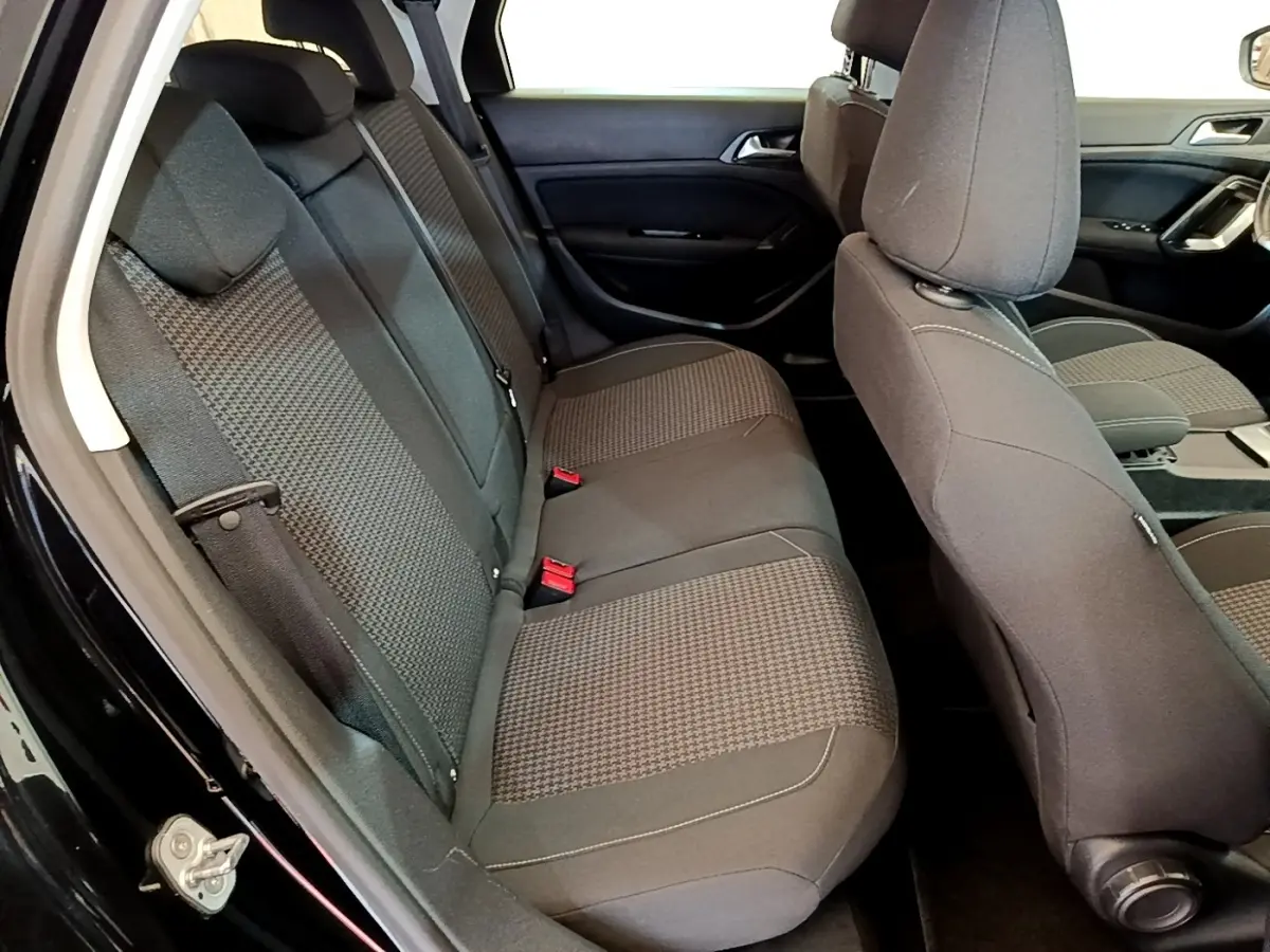 Vue intérieure côté gauche montrant la banquette arrière grise et les sièges avant du Peugeot 308 noir de 2020.