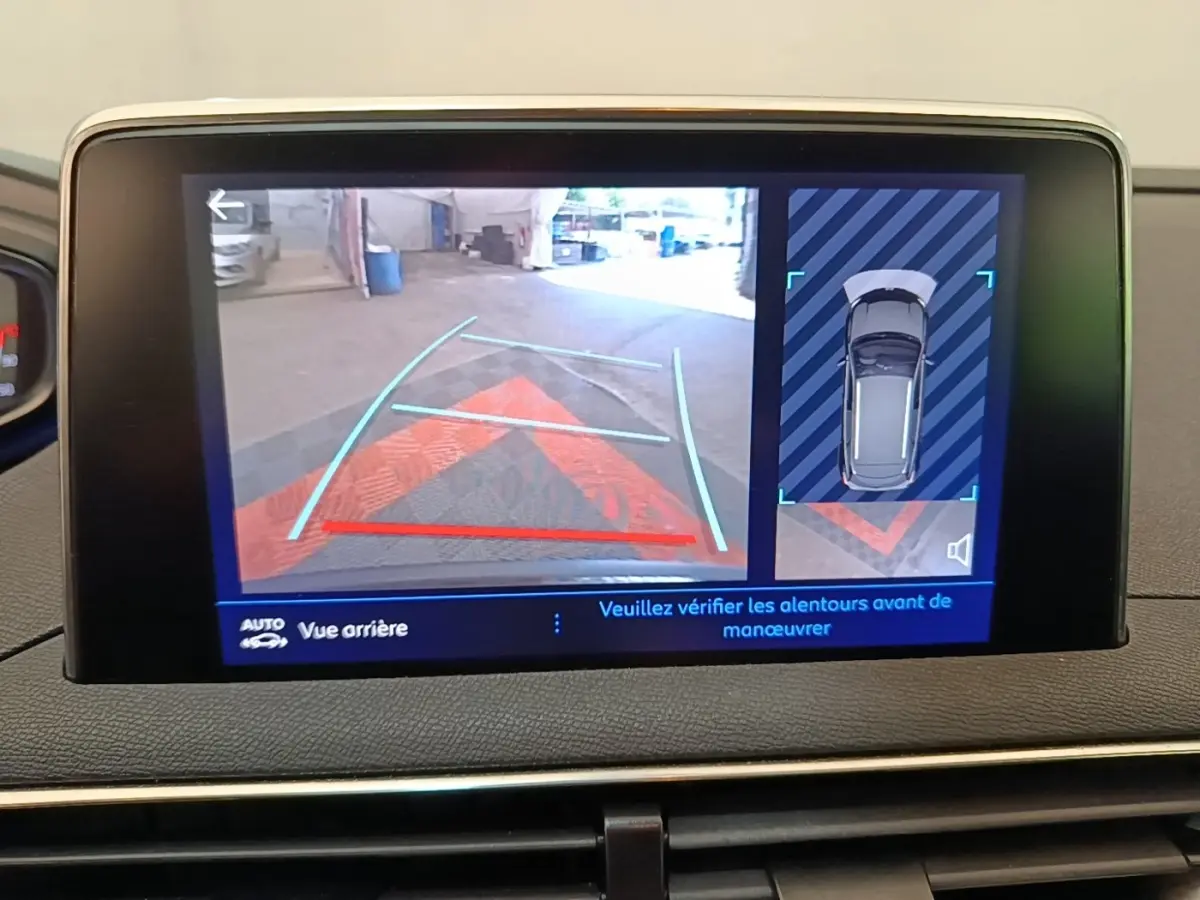 Écran tactile intérieur montrant la caméra de recul et l'aide au stationnement du Peugeot 3008 noir, vue arrière.