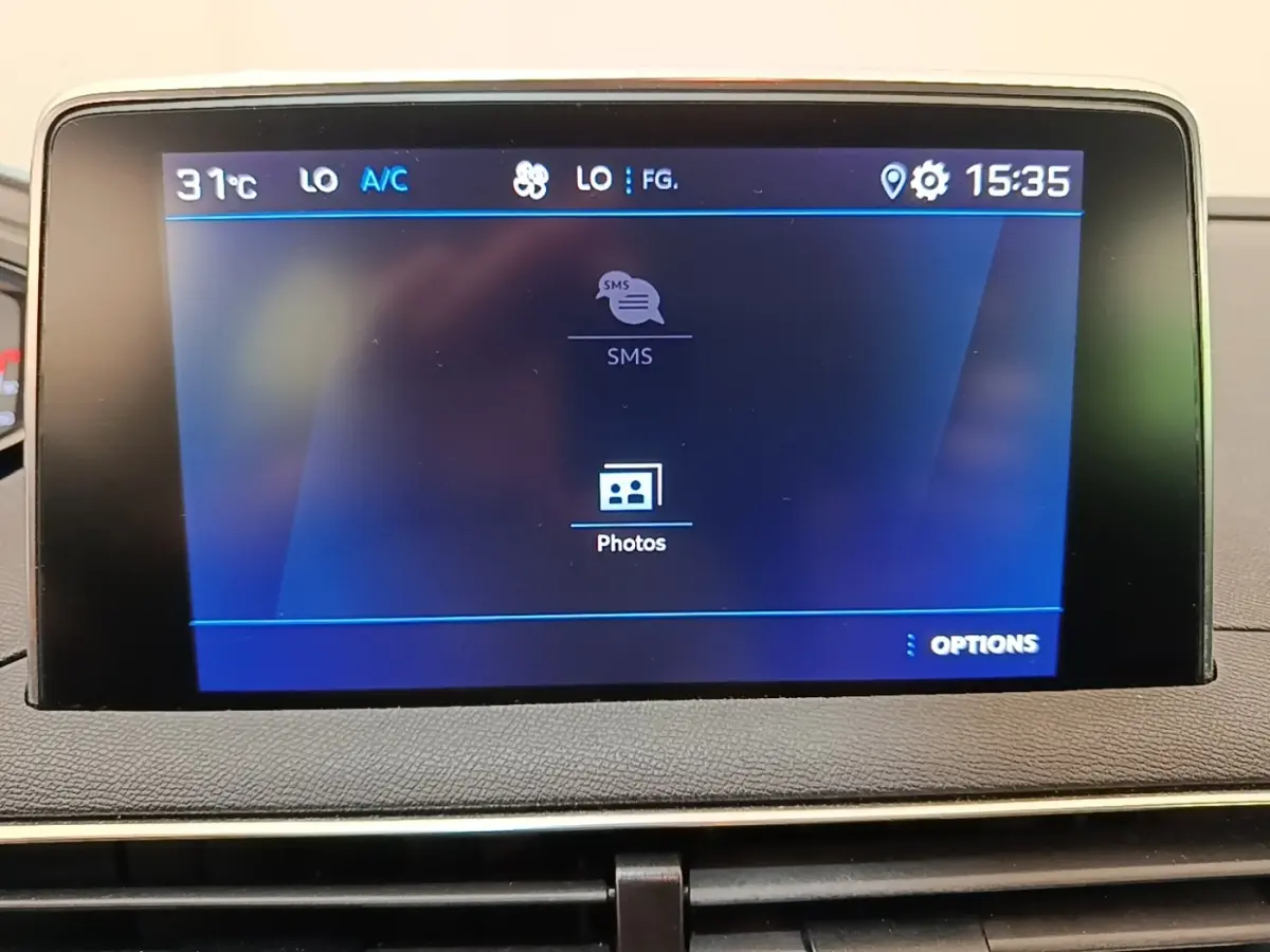 Écran tactile central du tableau de bord du Peugeot 3008 noir, affichant menu SMS et photos, vue frontale rapprochée.