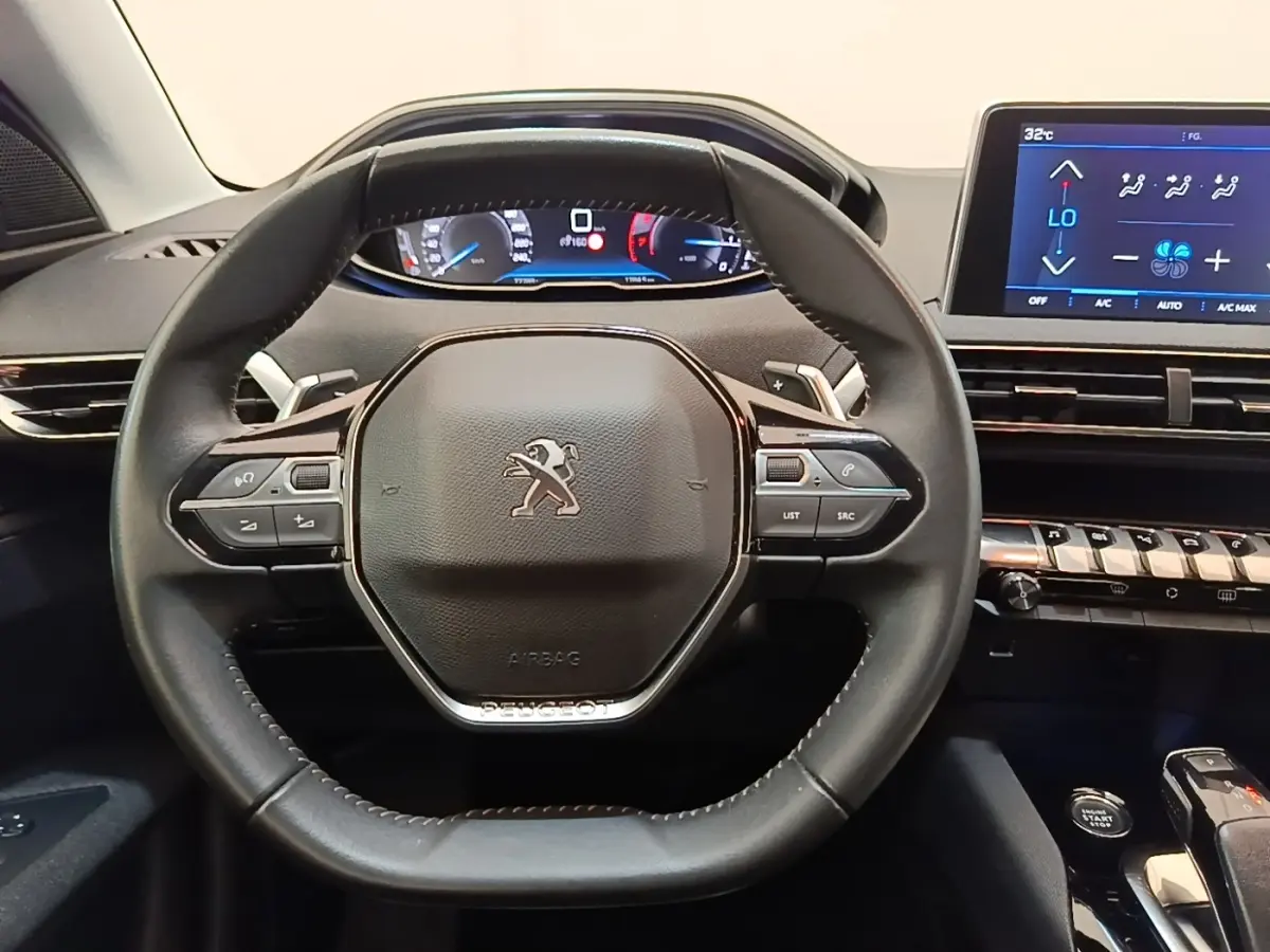 Vue rapprochée du volant cuir noir et du tableau de bord digital du Peugeot 3008 2022, avec écran tactile central.