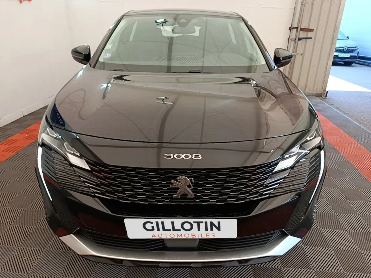 Vue frontale d’un Peugeot 3008 noir 2022 avec calandre noire et phares LED distinctifs allumés.