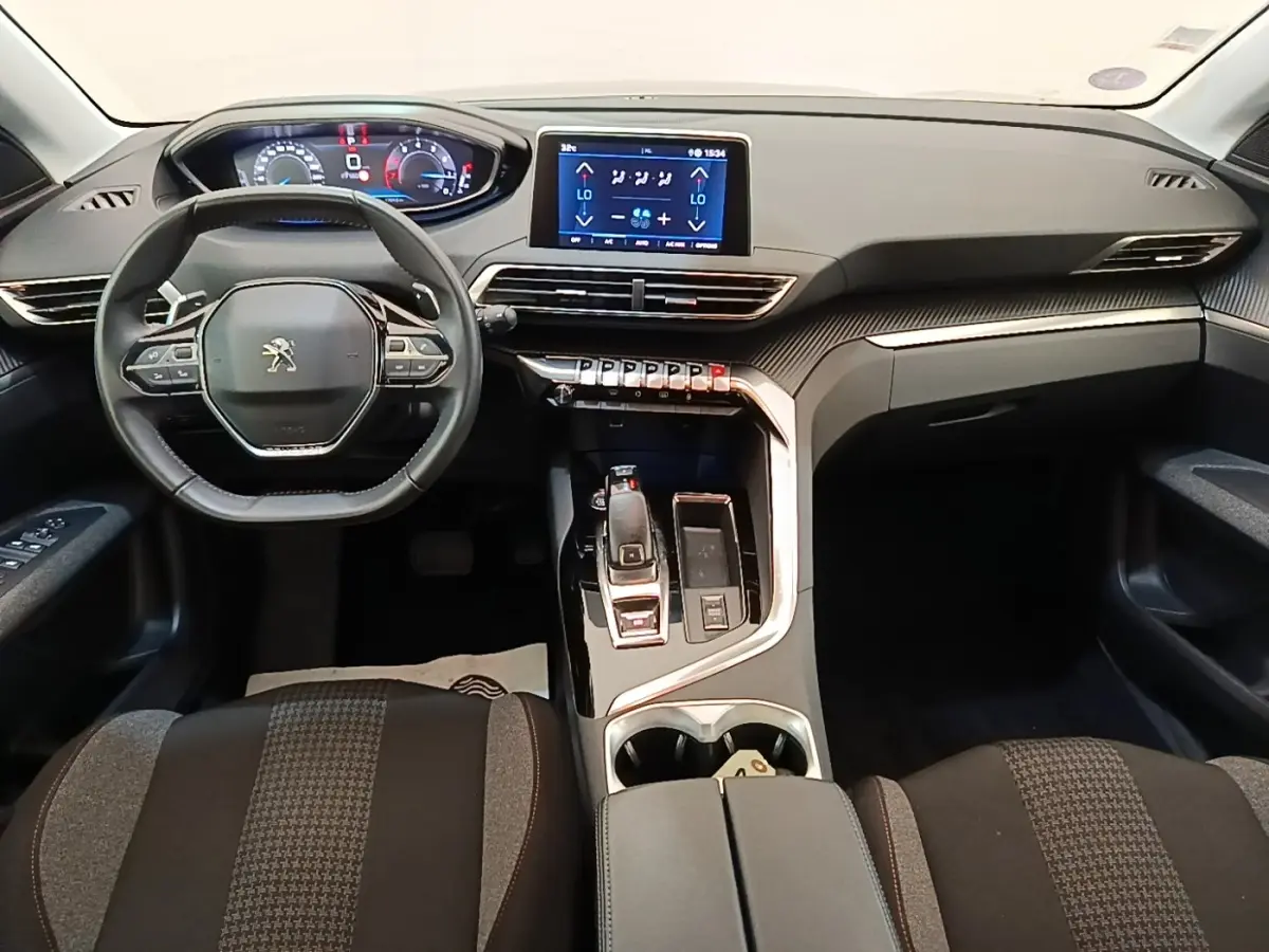Vue intérieure avant du Peugeot 3008 2022 noir, tableau de bord moderne avec écran tactile central et volant multifonctions cuir.