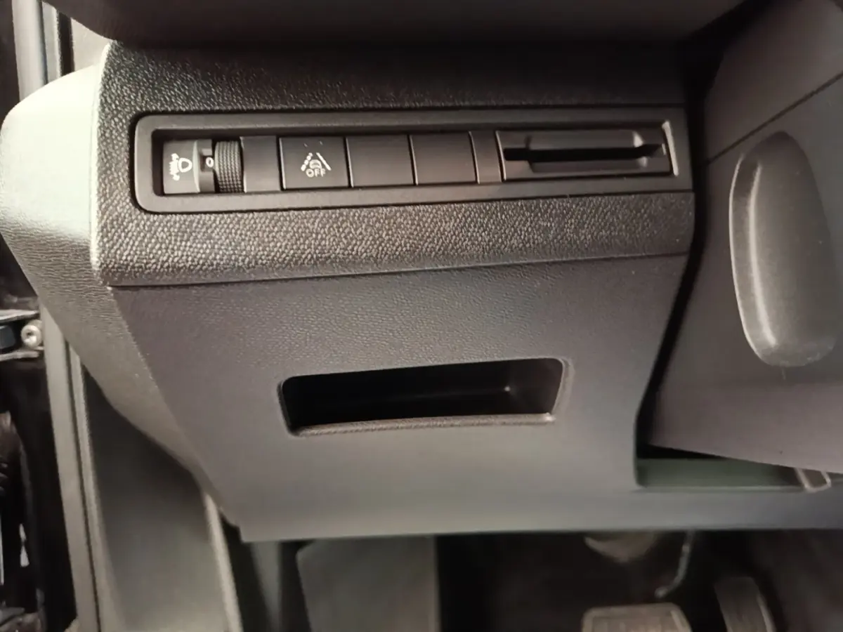 Vue intérieure côté gauche du tableau de bord noir du Peugeot 3008 2022 avec commandes d’éclairage et aide à la conduite.