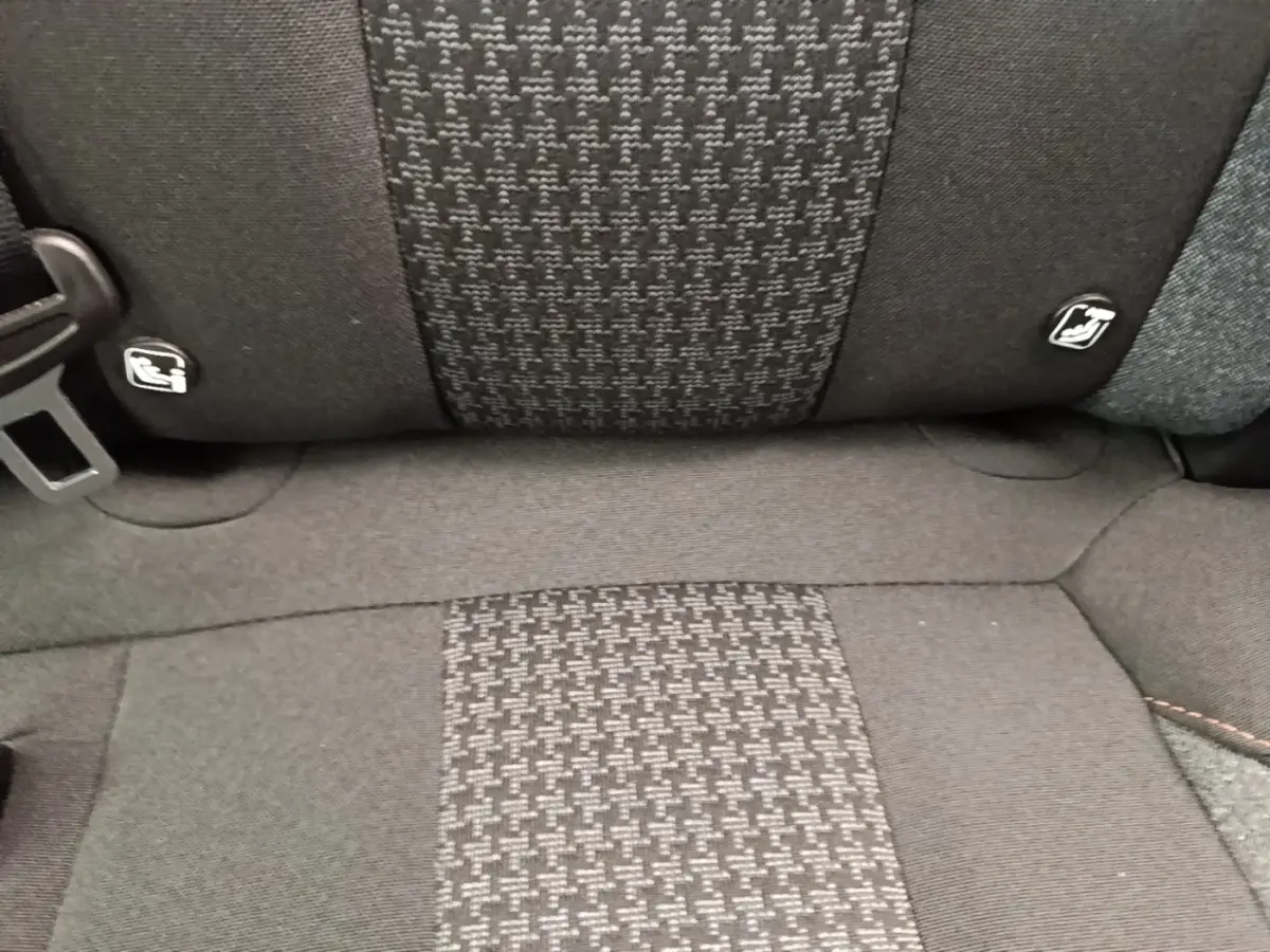 Gros plan sur la banquette arrière noire du Peugeot 3008 2022, tissu à motif central et ceintures visibles.