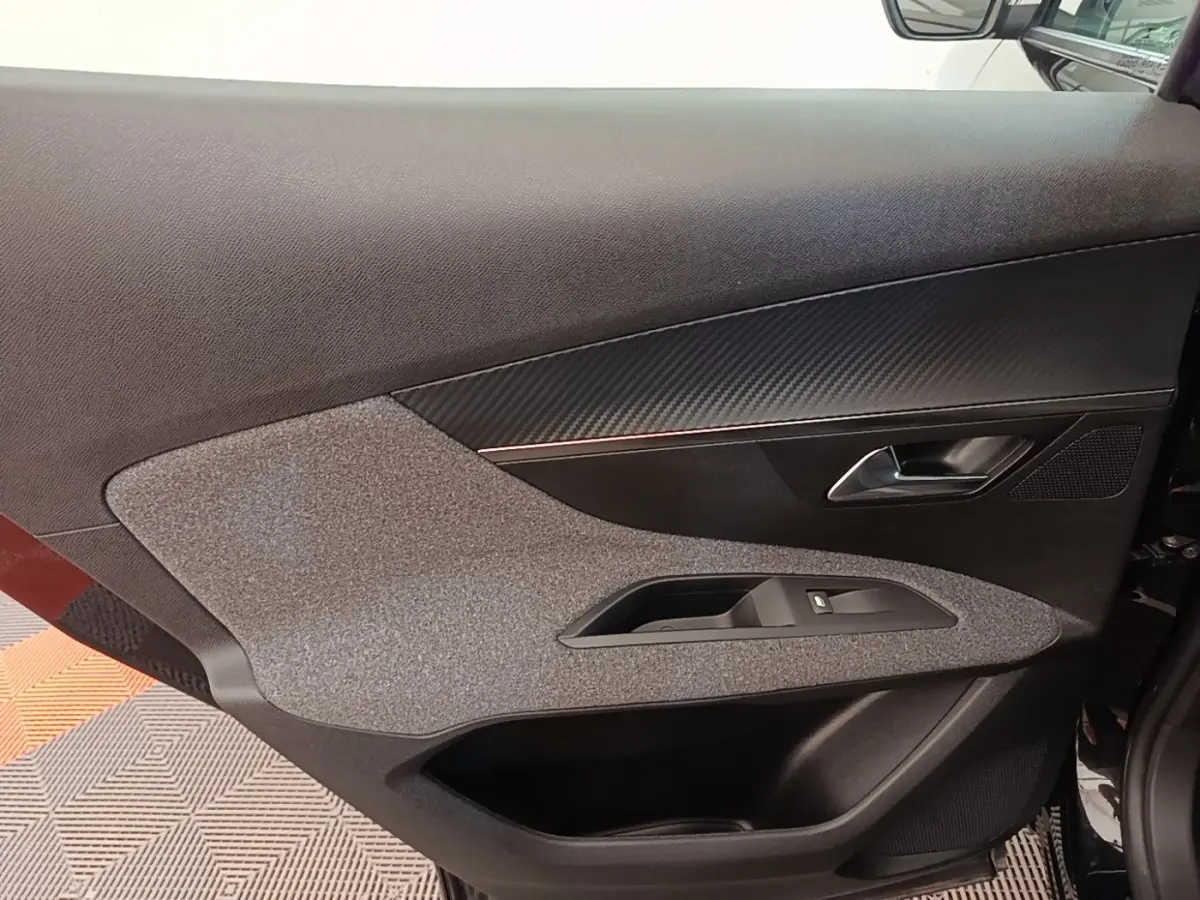 Gros plan sur la porte intérieure côté conducteur du Peugeot 3008 noir, avec habillage tissu et garniture noire.