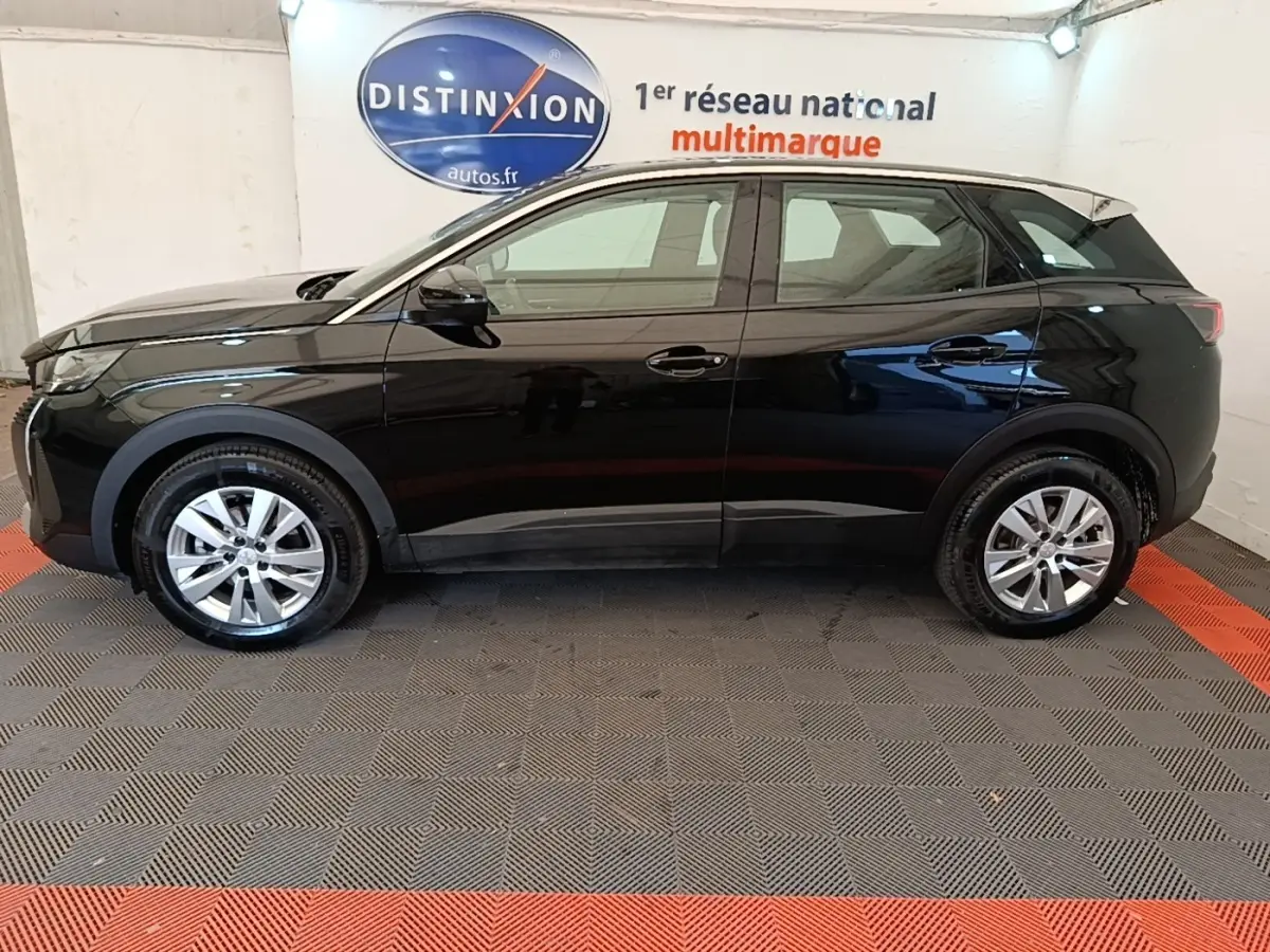 Profil droit noir brillant du Peugeot 3008 PureTech 130 2022 dans un showroom avec sol à damier gris et rouge.