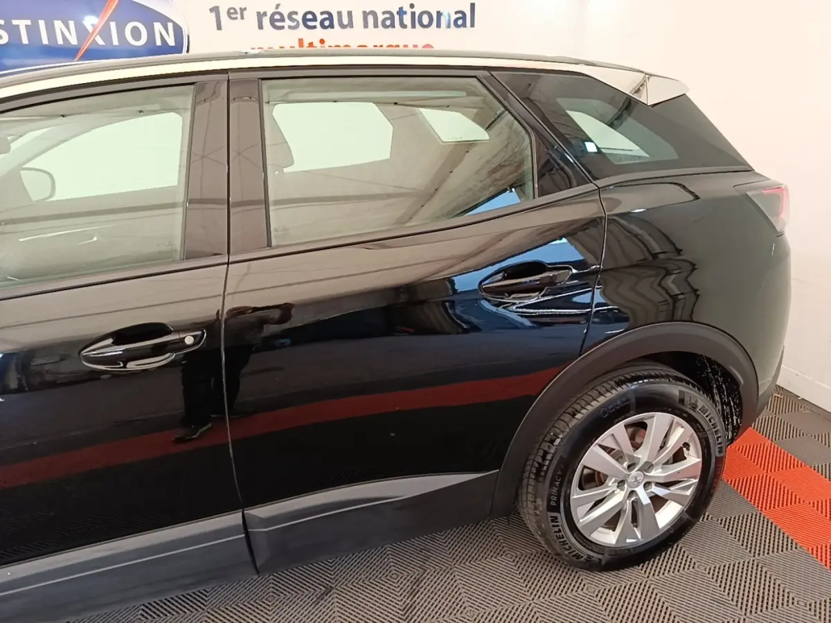 Vue latérale droite d'un Peugeot 3008 noir 2022 avec toit blanc et jantes alliage argentées.