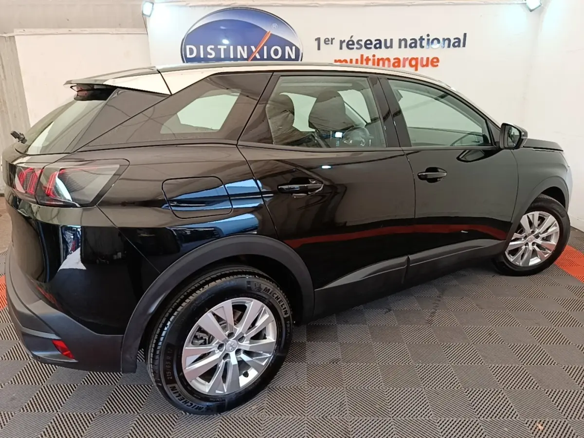 Vue 3/4 arrière droite d’un Peugeot 3008 noir 2022 avec jantes alliage et vitres teintées en intérieur showroom.
