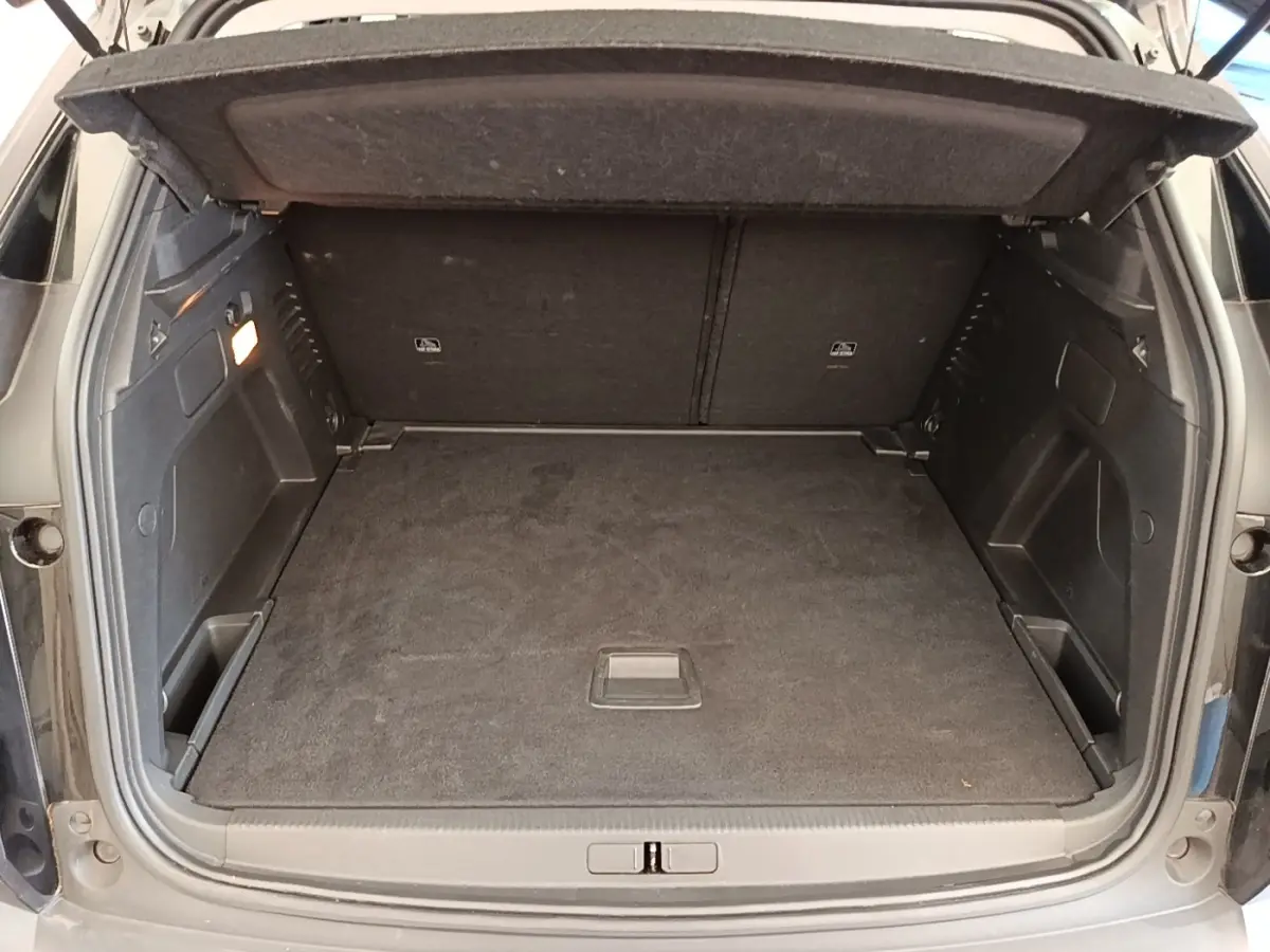 Coffre ouvert du Peugeot 3008 noir, vue arrière montrant l'espace de chargement avec tablette de séparation.