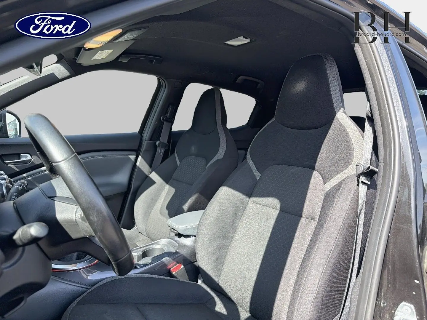 Vue intérieure côté droit sur les sièges avant en tissu gris du Nissan Juke noir métallisé de 2020.
