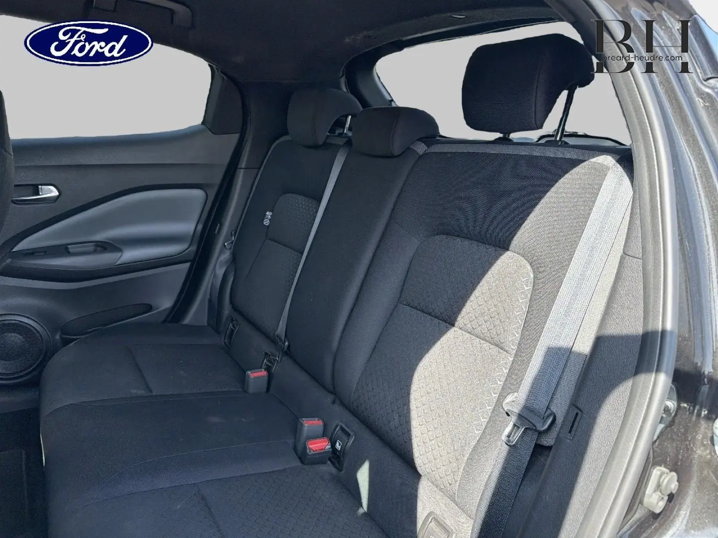 Vue intérieure côté droit montrant la banquette arrière noire avec appuie-têtes et ceinture de sécurité du Nissan Juke 2020.