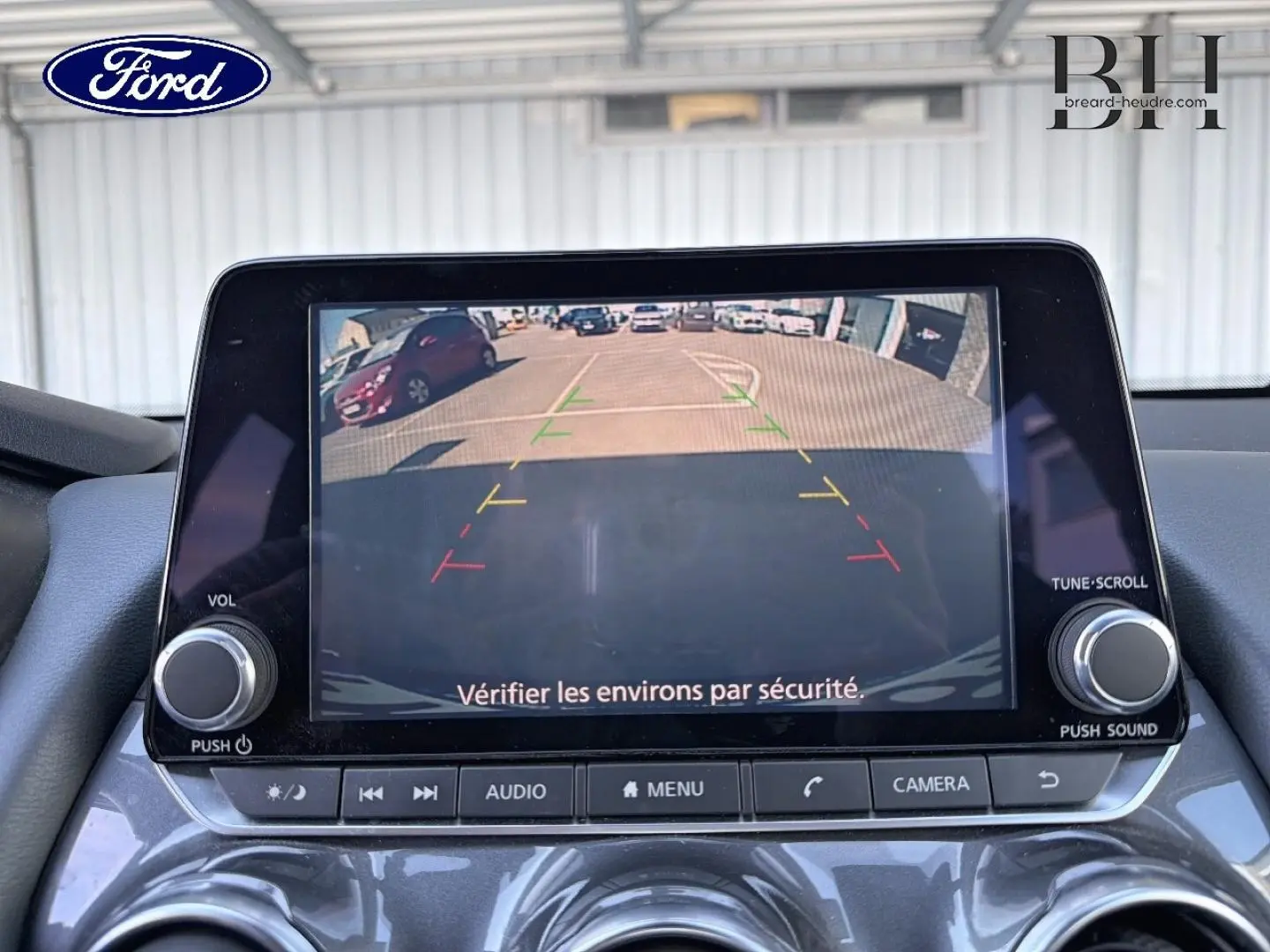 Écran tactile de caméra de recul dans un Nissan Juke noir métallisé, vue intérieure frontale du tableau de bord.