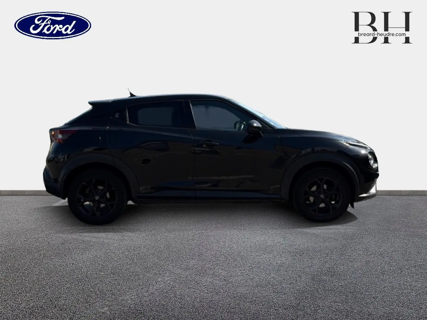 Vue de profil côté gauche d'un Nissan Juke noir métallisé avec jantes noires sur fond clair.