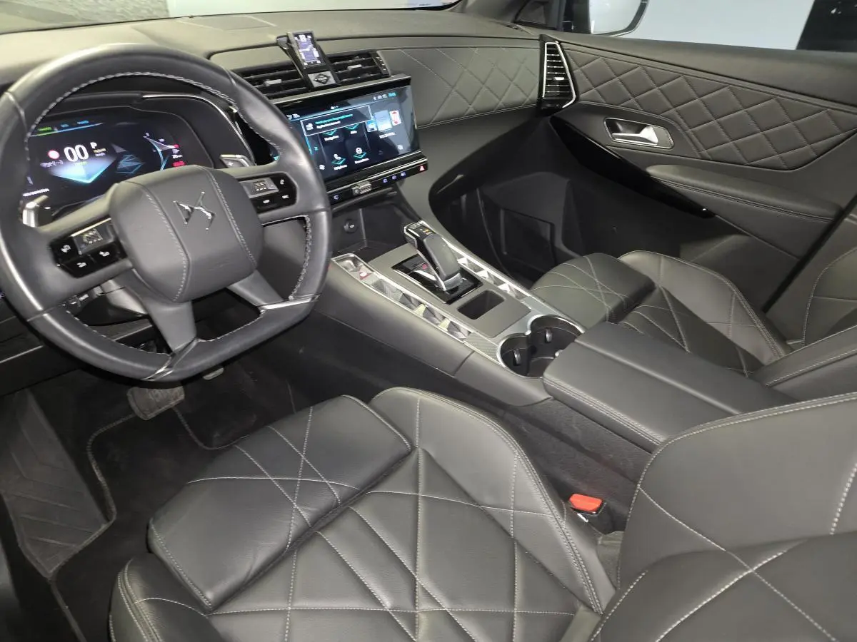 Vue intérieure côté conducteur du DS7 Crossback 2024, sellerie cuir noir avec console centrale et écran tactile.