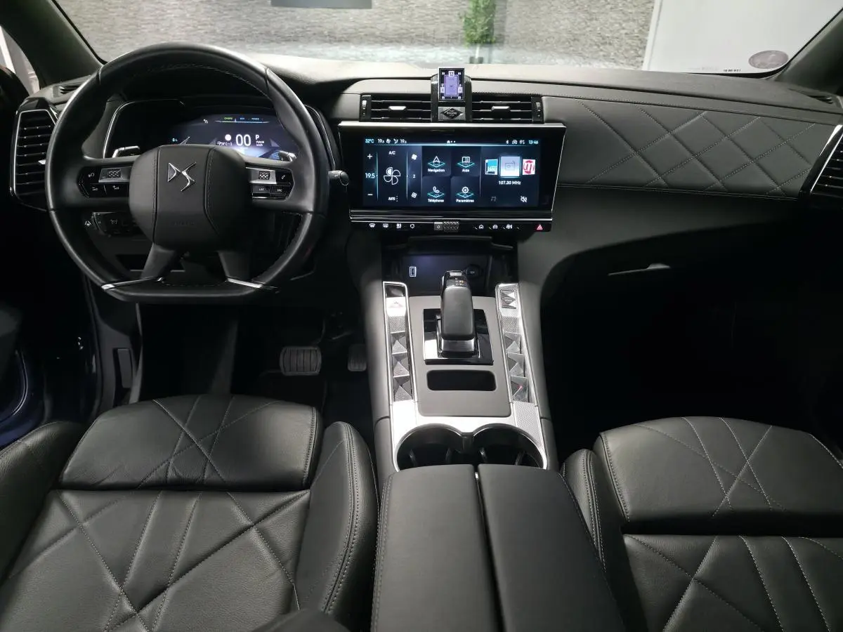 Vue intérieure avant du DS7 Crossback 2024, tableau de bord et console centrale en cuir noir avec écran tactile HD.