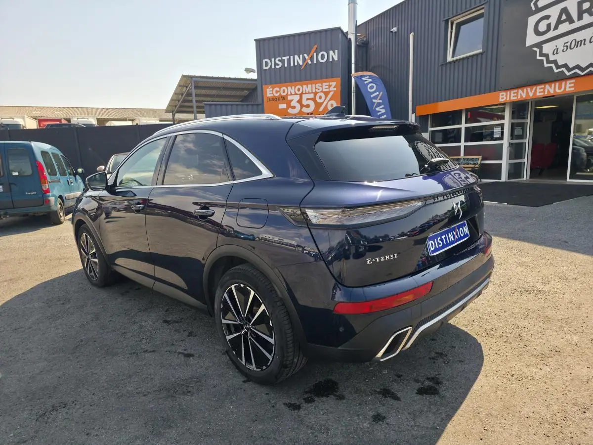 Vue 3/4 arrière droite d’un DS7 Crossback E-Tense bleu métallisé avec jantes 19’’ et double sortie d’échappement chromée.