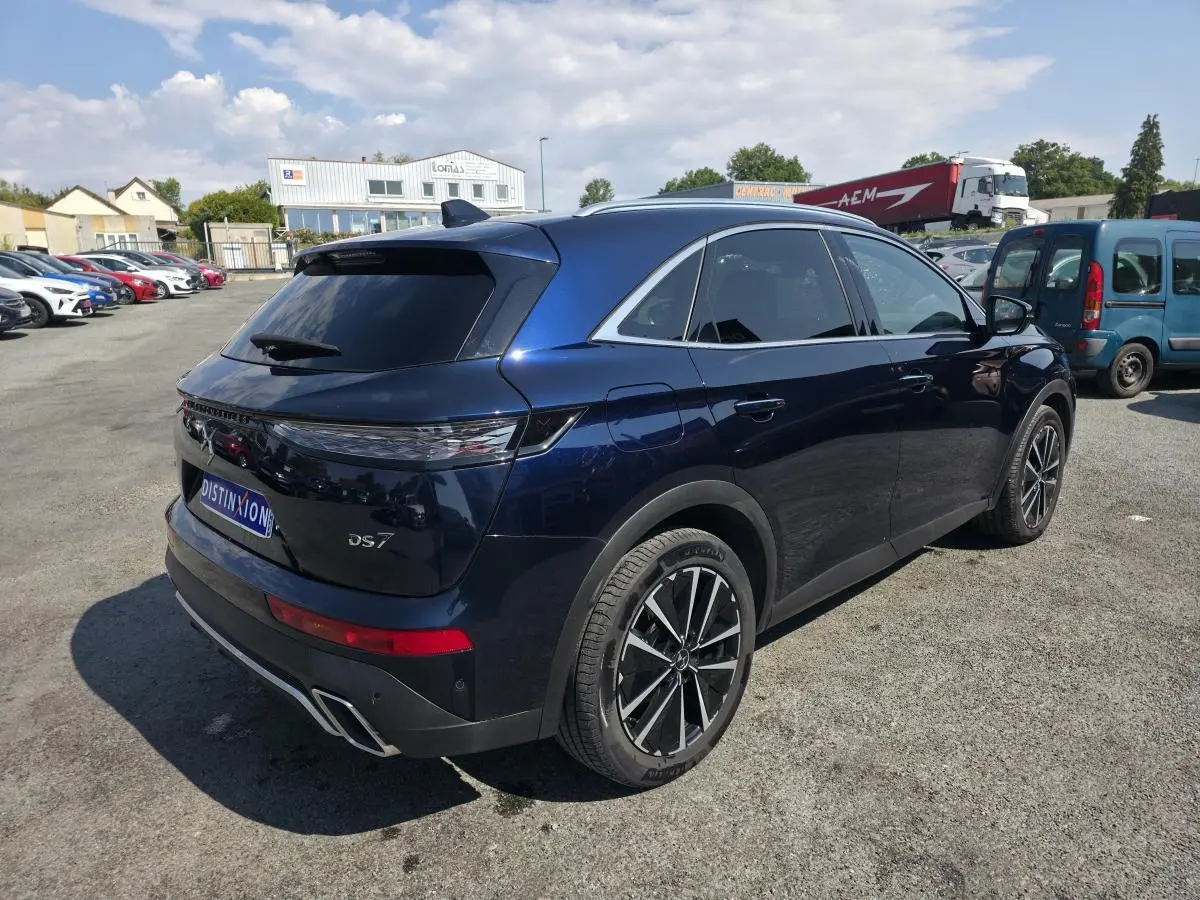 Vue 3/4 arrière droite du DS7 Crossback E-Tense bleu métallisé avec jantes alliage et feux arrière 3D à LED.