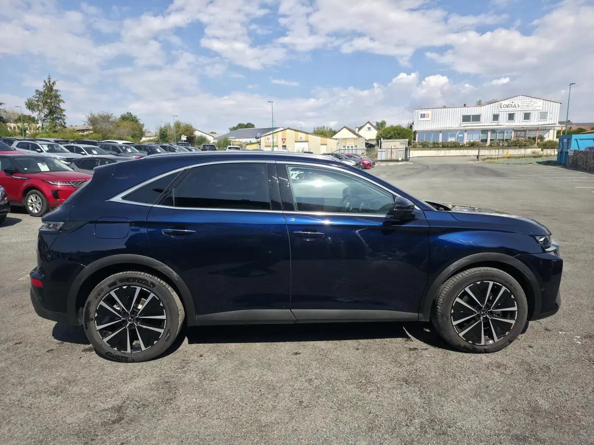 Vue latérale droite du DS7 Crossback E-Tense 225 bleu métallisé avec jantes alliage noires et vitres arrière surteintées.