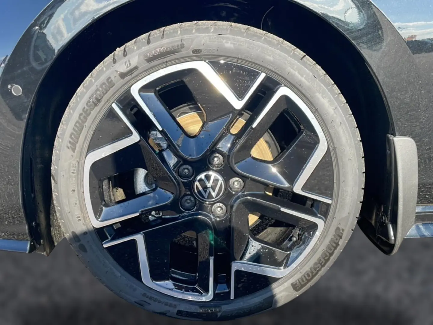 Gros plan sur la jante noire et argentée d’une Volkswagen Golf 2026, avec logo VW au centre.