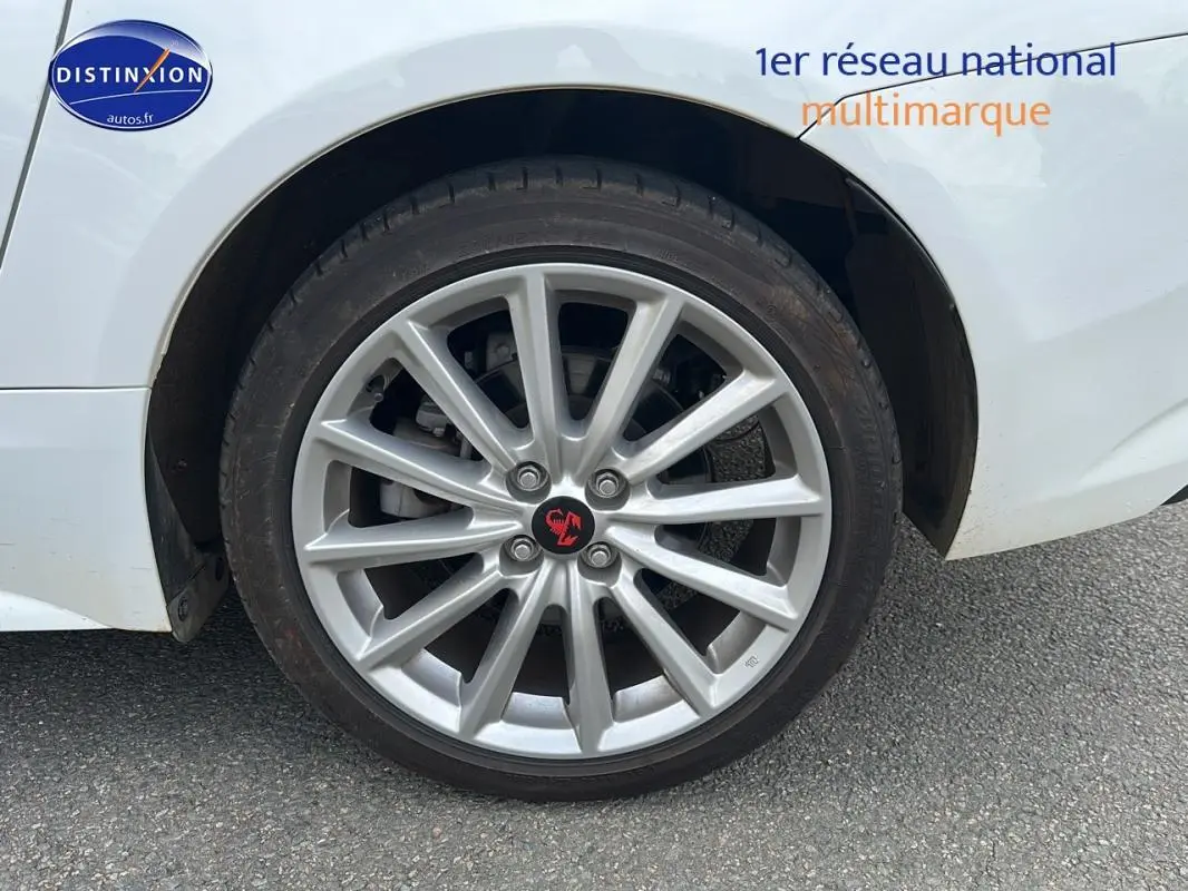 Gros plan sur la jante alliage 17 pouces argentée d'une FIAT 124 SPIDER blanc, côté arrière droit.