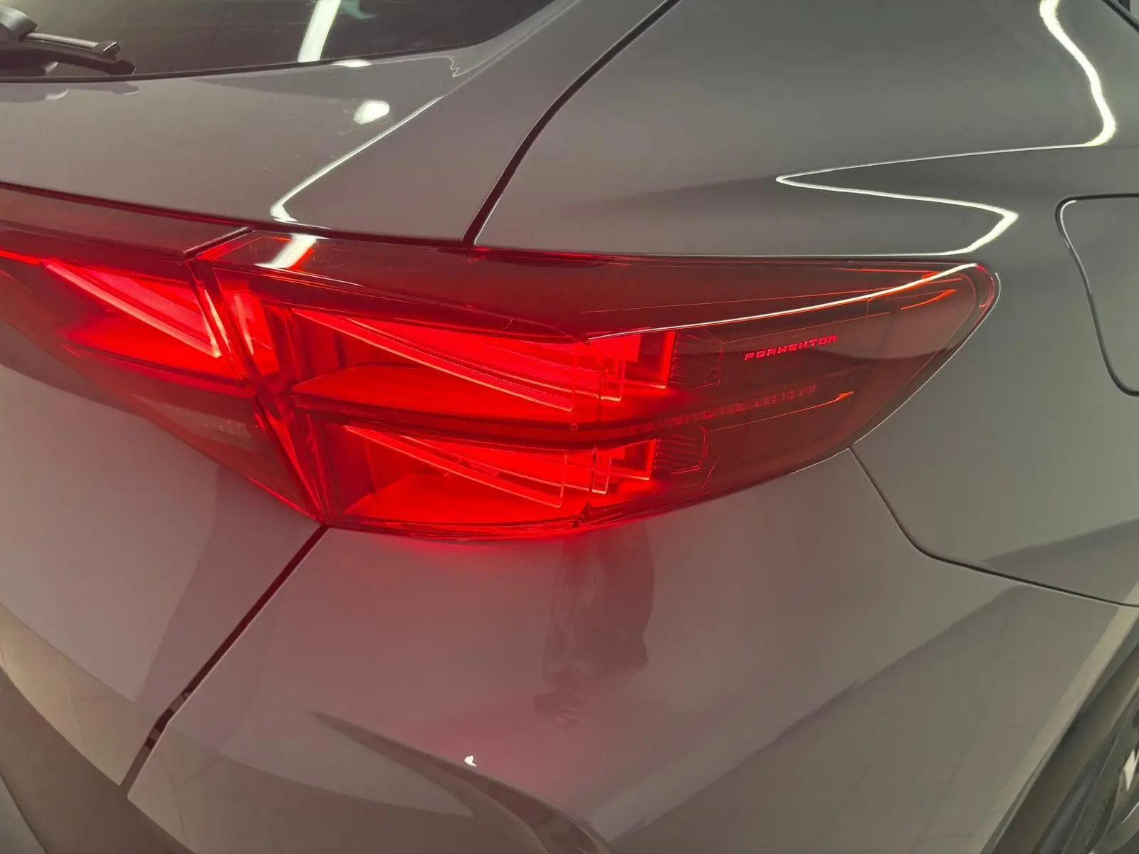 Gros plan sur le feu arrière droit rouge du CUPRA Formentor 2025 gris Graphène avec peinture spéciale et toit ouvrant.