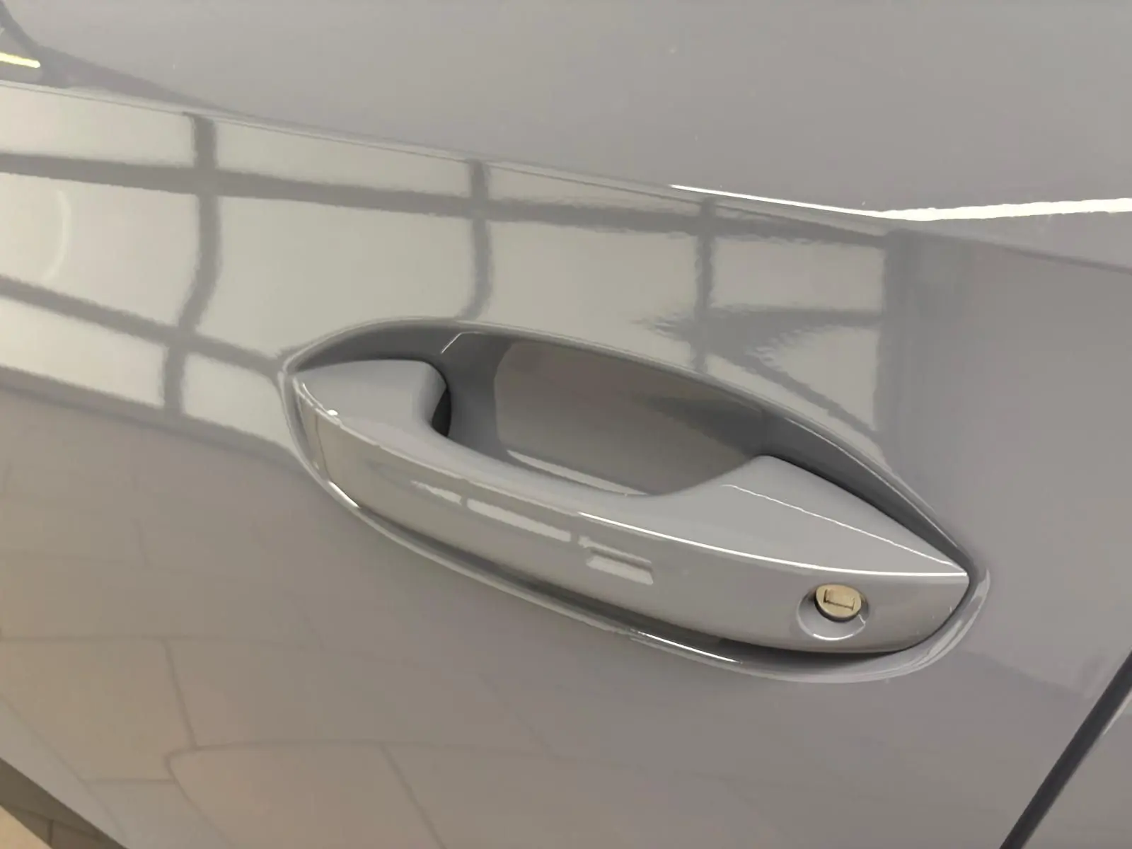 Poignée de porte côté gauche du CUPRA Formentor 2025 en gris Graphène avec serrure intégrée visible.