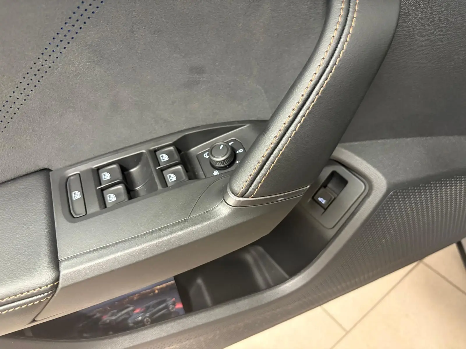 Gros plan sur la commande des vitres et rétroviseurs côté conducteur du CUPRA Formentor 2025 avec surpiqûres orange.