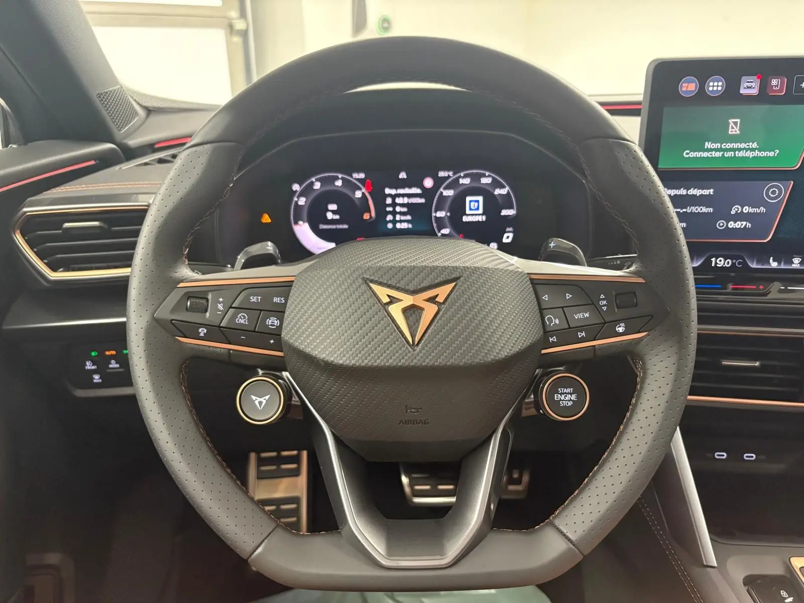 Vue rapprochée du volant perforé en cuir avec logo CUPRA cuivre et tableau de bord numérique du Formentor 2025.