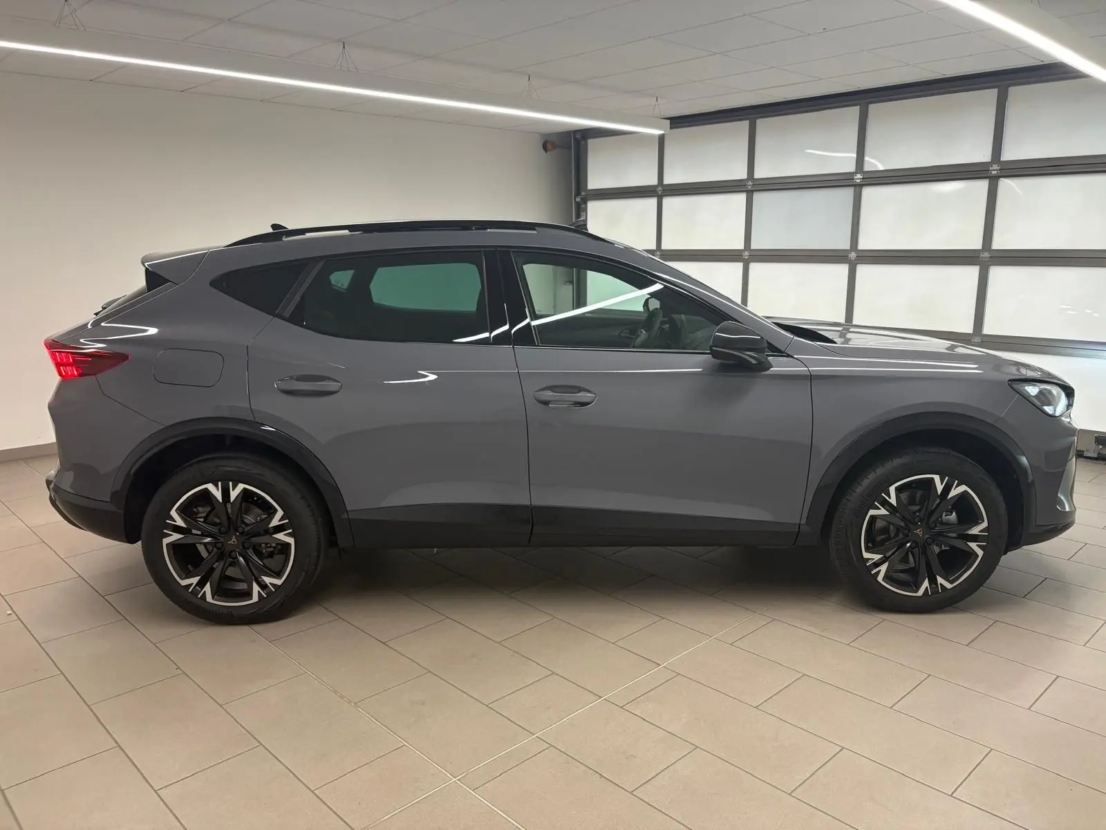 Profil côté gauche du CUPRA Formentor 2025 gris Graphène avec toit ouvrant panoramique et jantes alliage 18'' usinées.