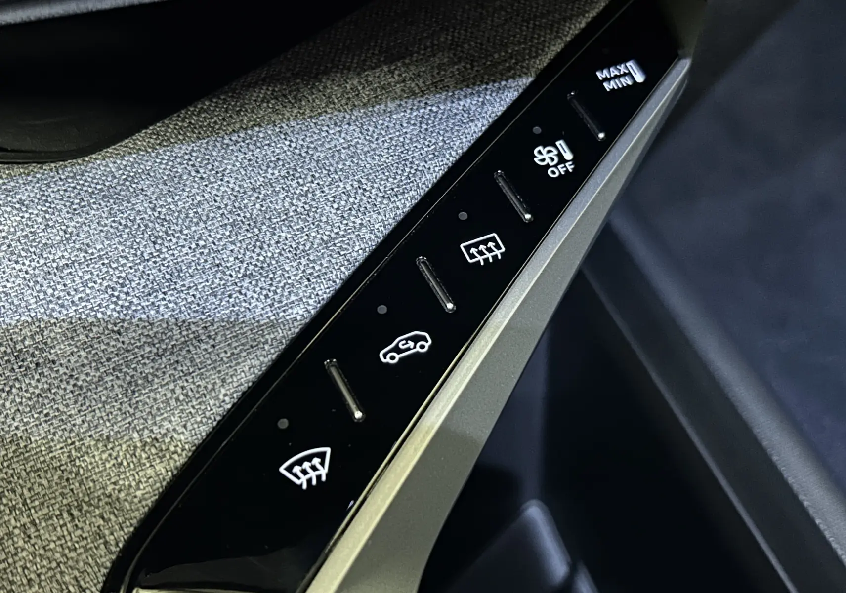 Gros plan sur les commandes de climatisation tactile en noir brillant et tissu gris à l'intérieur d'un Peugeot 3008 Bleu Ingaro 2025.