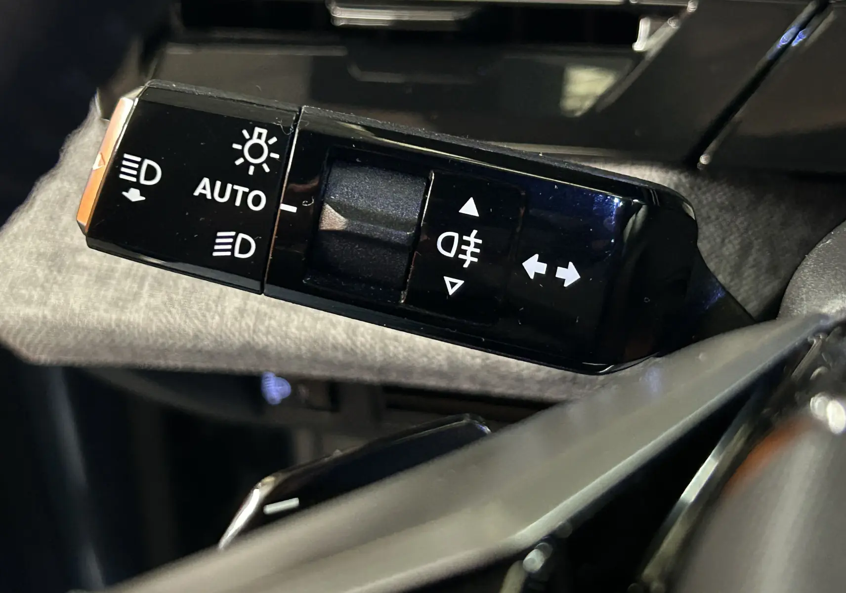 Gros plan sur la commande des phares et clignotants dans l'habitacle du Peugeot 3008 III Hybrid 145 e-DSC6 Allure 2025.