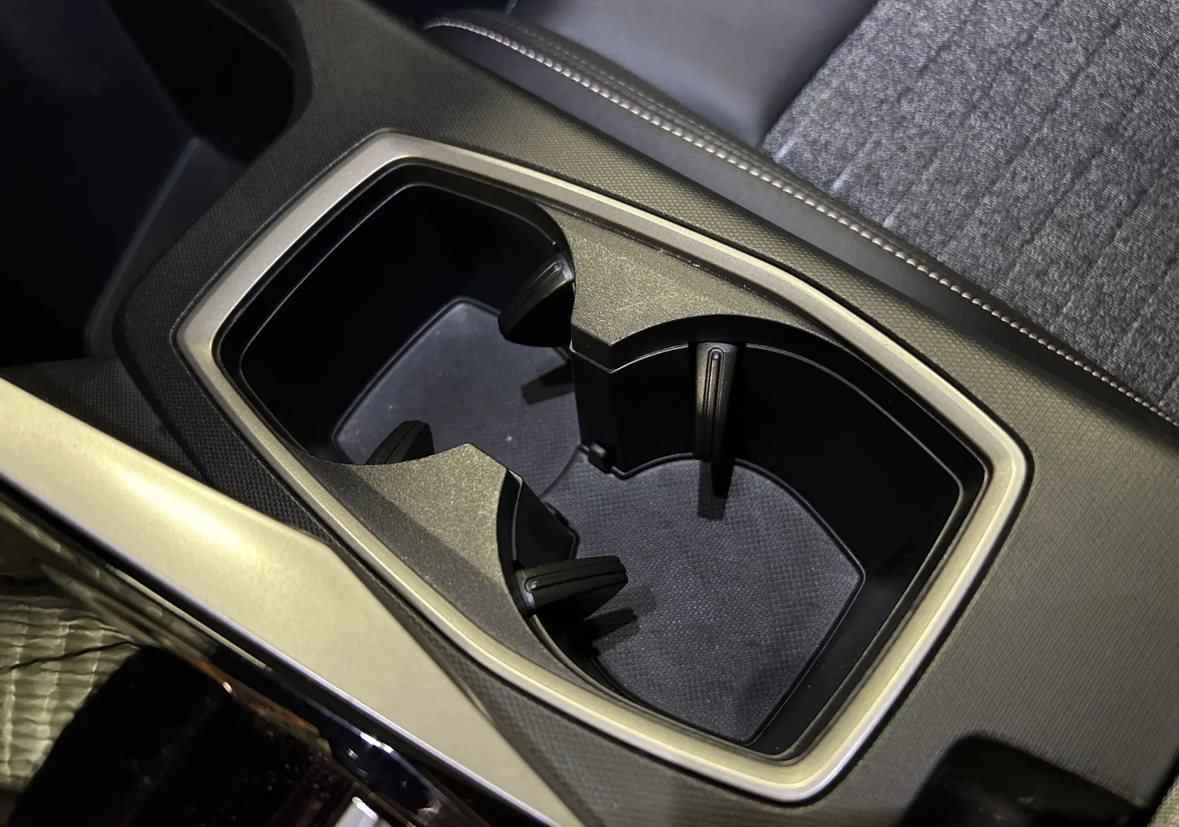 Gros plan sur les porte-gobelets noirs et la console centrale du Peugeot 3008 III HYBRID 145 e-DSC6 Allure.