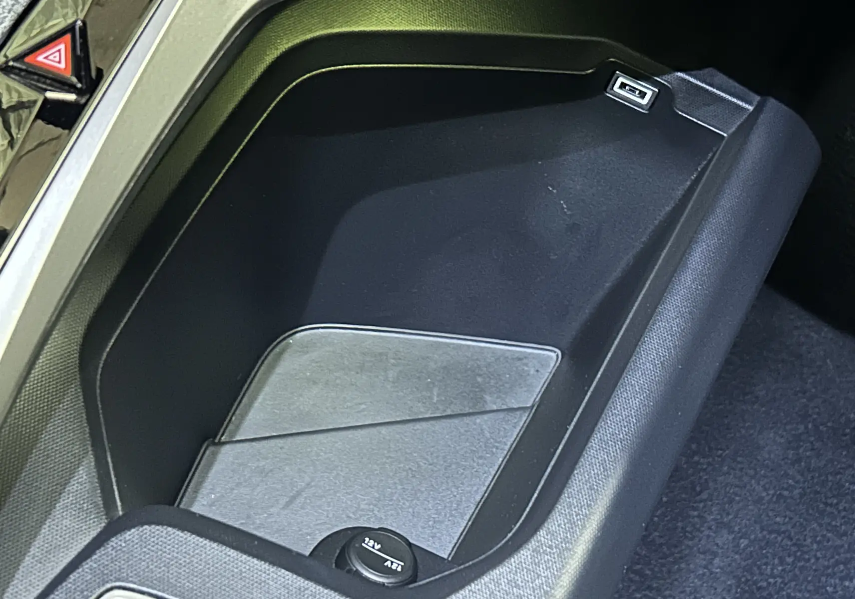 Espace de rangement central noir avec prise USB et allume-cigare dans un Peugeot 3008 2025.