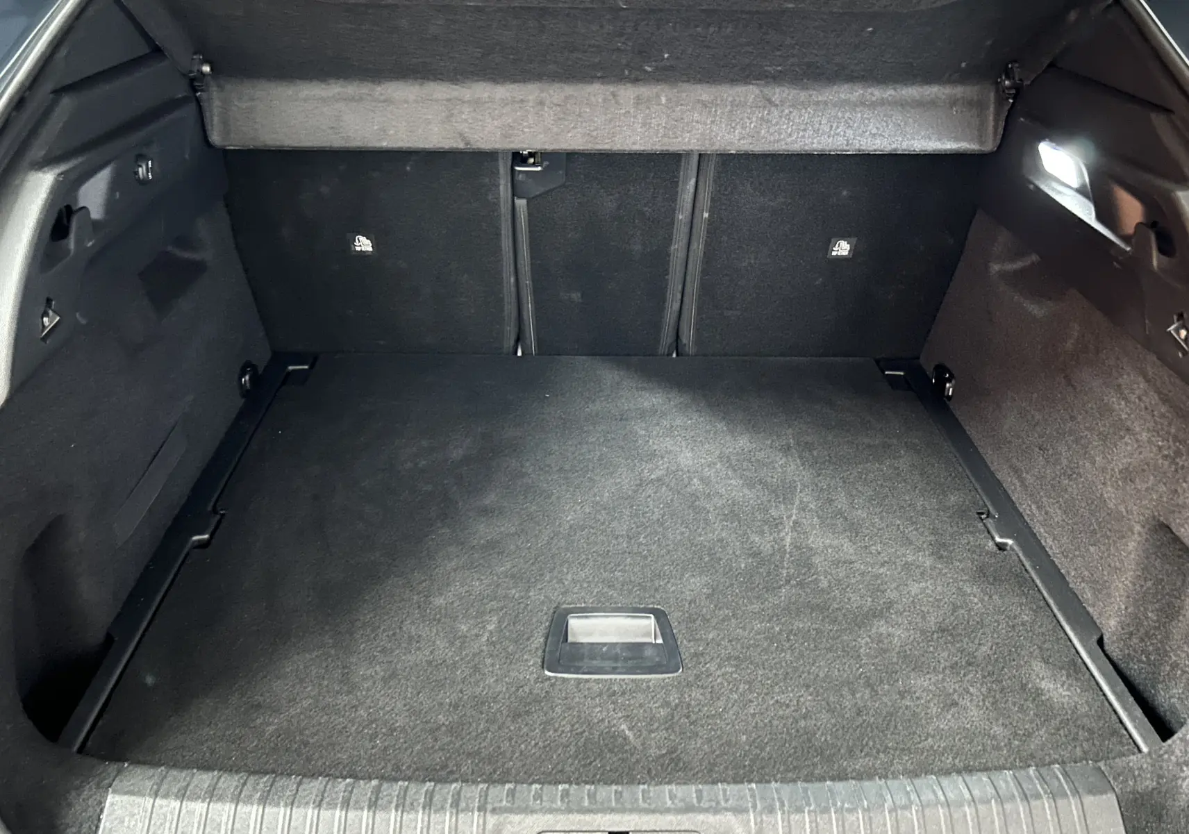 Coffre spacieux et propre du Peugeot 3008 III Hybrid 145 e-DSC6 Allure en vue intérieure arrière, revêtement noir.